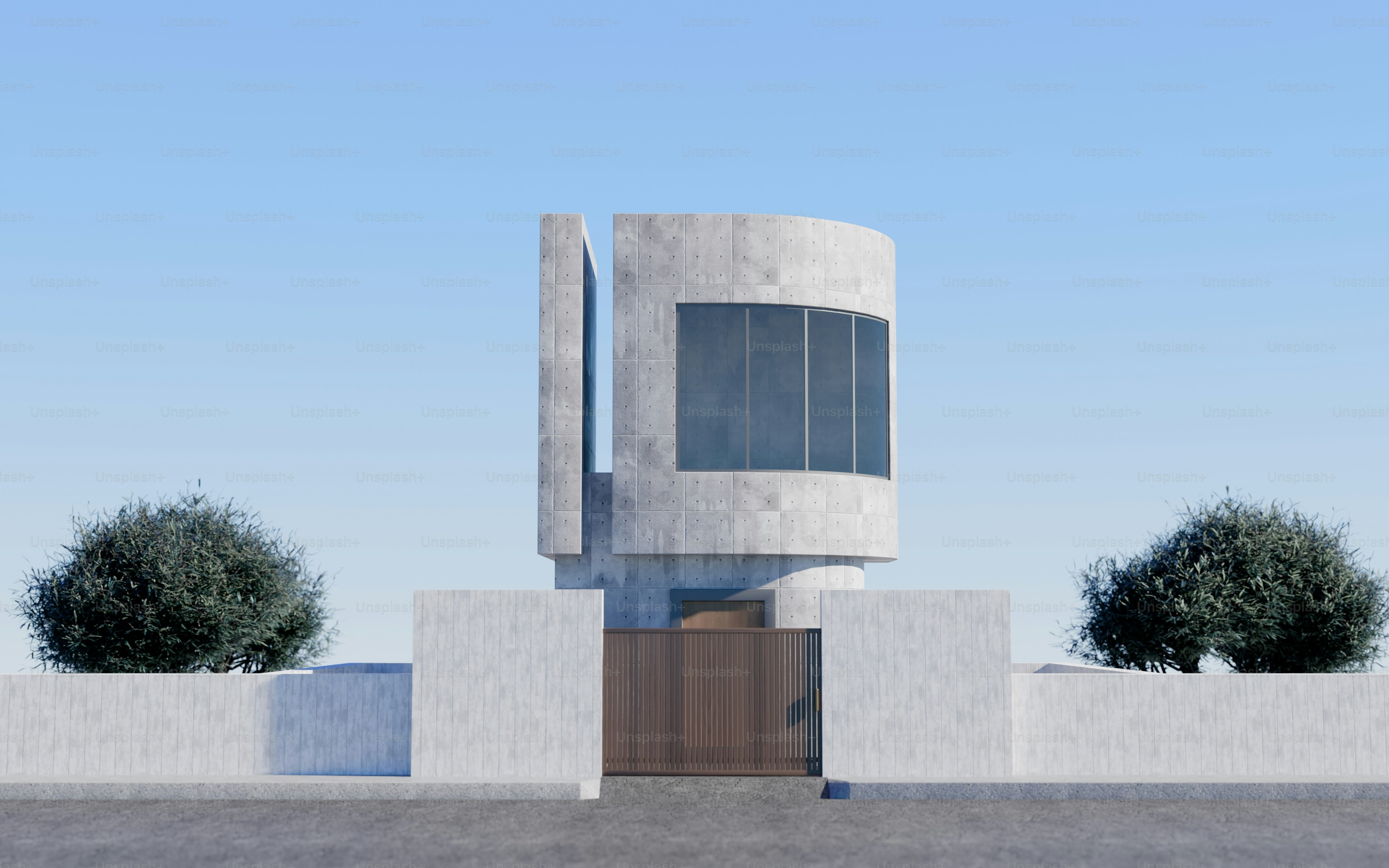 Un edificio moderno de hormigón con una fachada curva detrás de un muro perimetral bajo