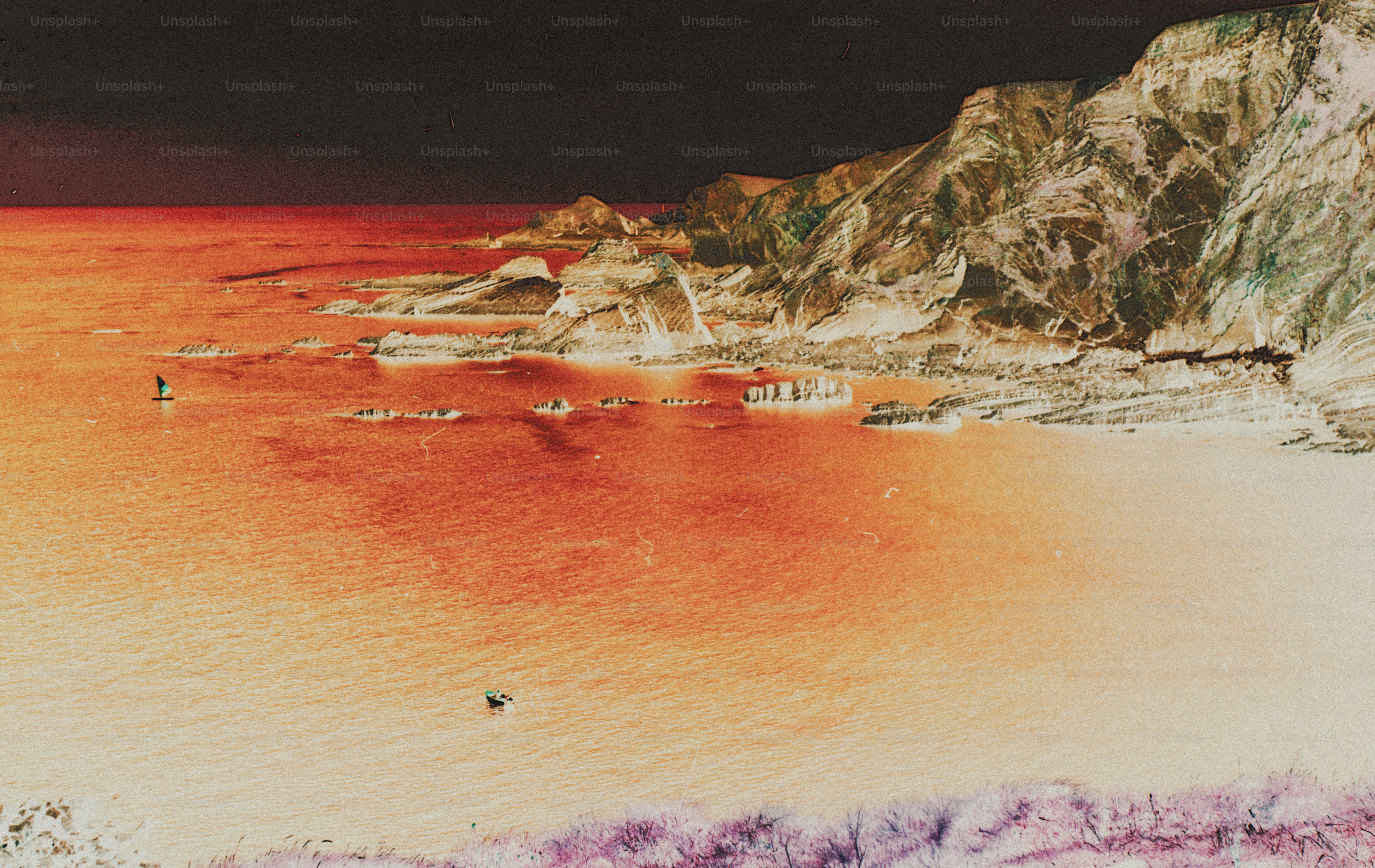 A small boat on orange water near rocky cliffs and a sandy beach