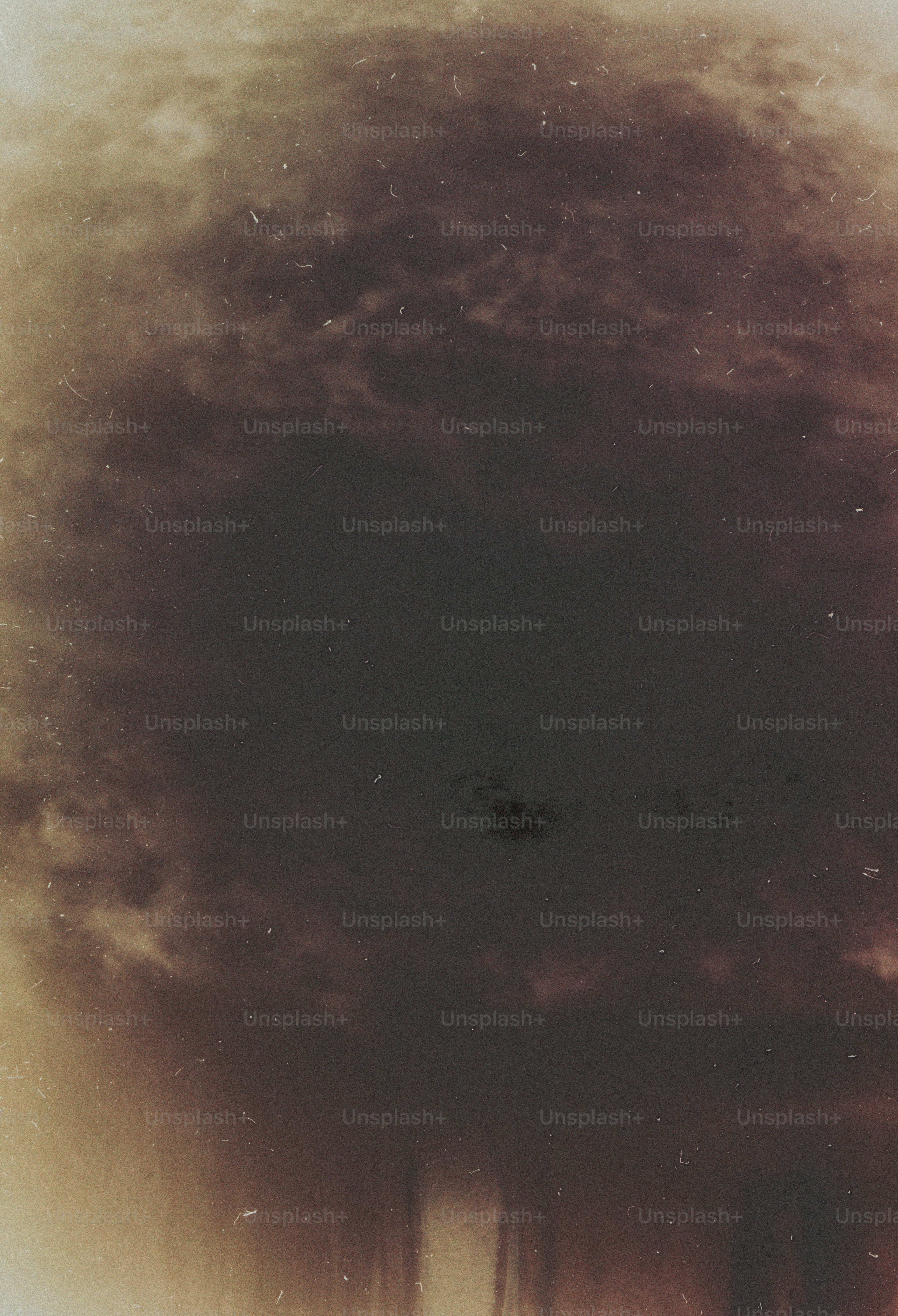 A dark circular vignette with a grainy texture and warm sepia tones