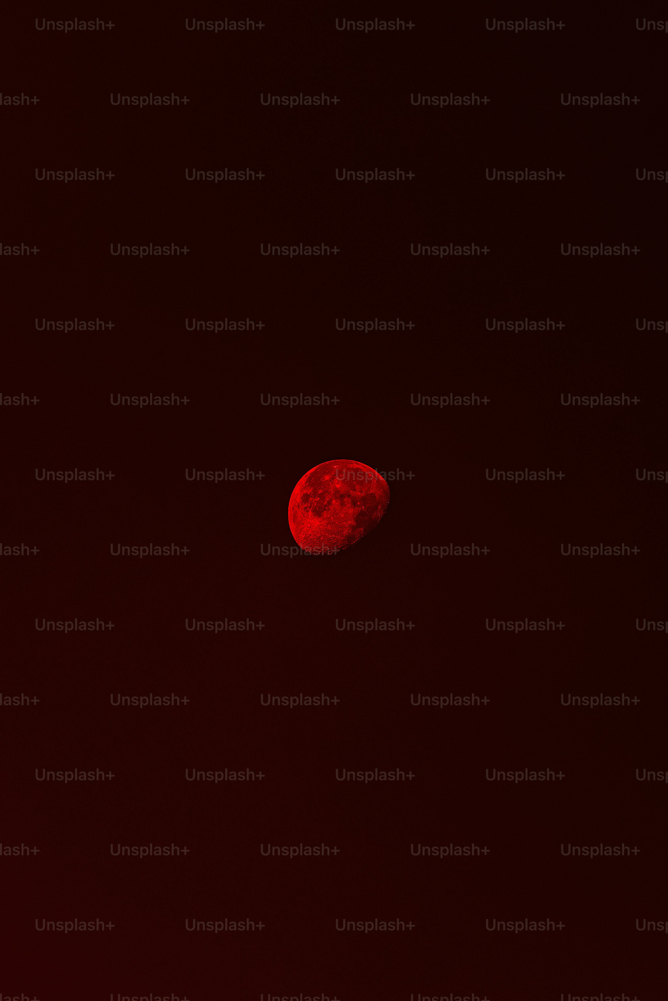 Una luna crescente che brillava di un rosso intenso contro un cielo scuro
