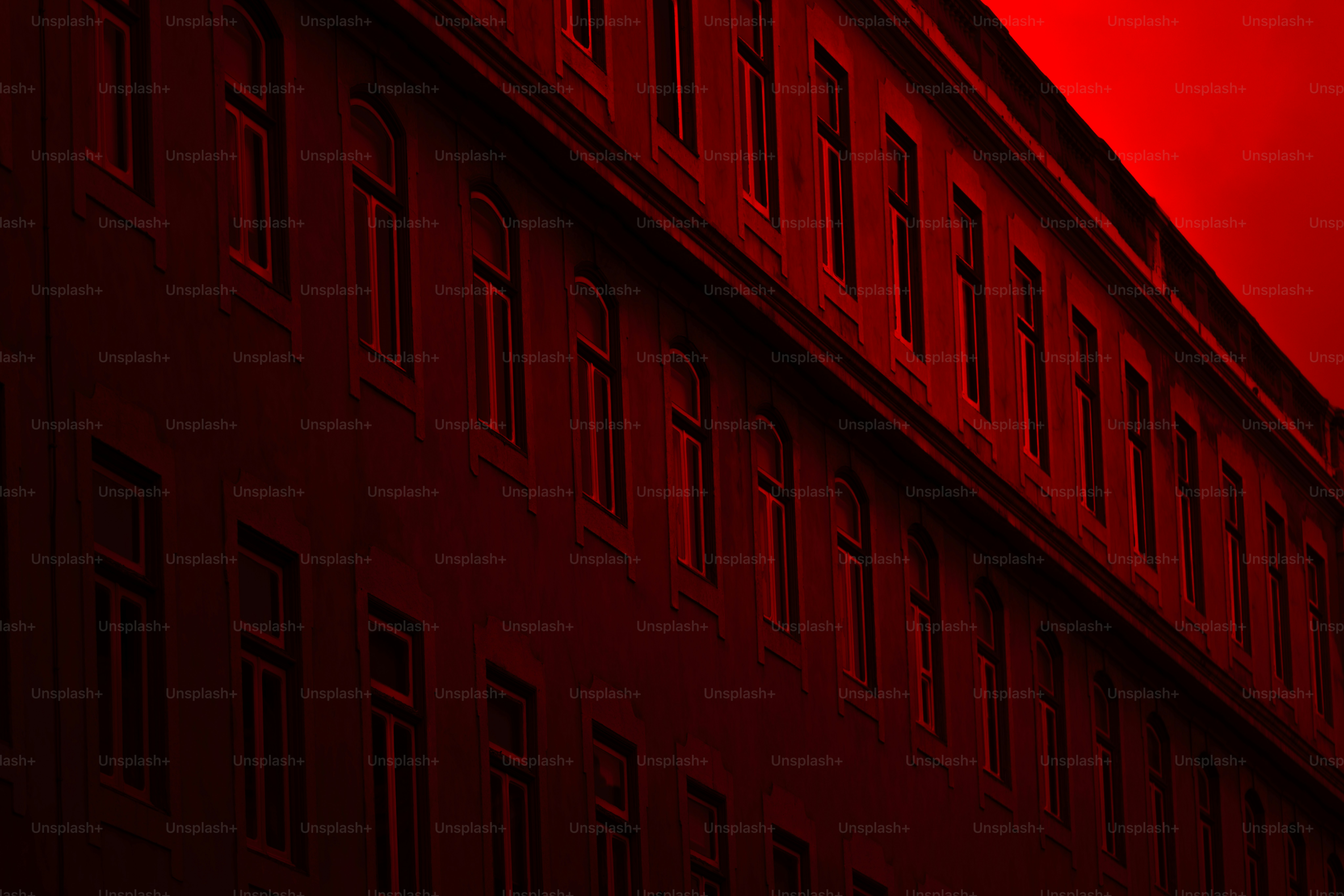 Una facciata di edificio con molte finestre illuminate da una luce rossa intensa