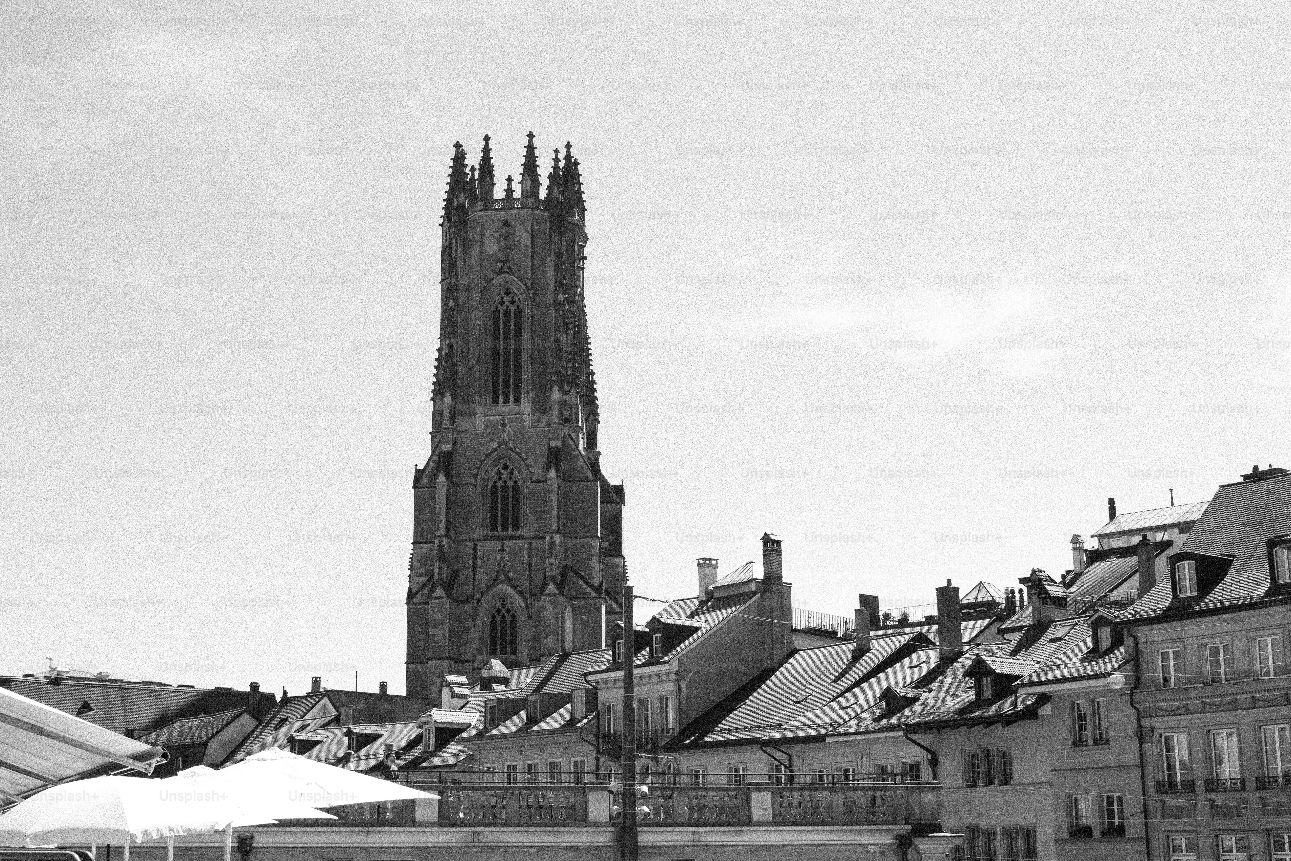 Der Turm des Sankt-Nikolaus-Doms, der über historischen Dächern in Freiburg, Schweiz, emporragt
