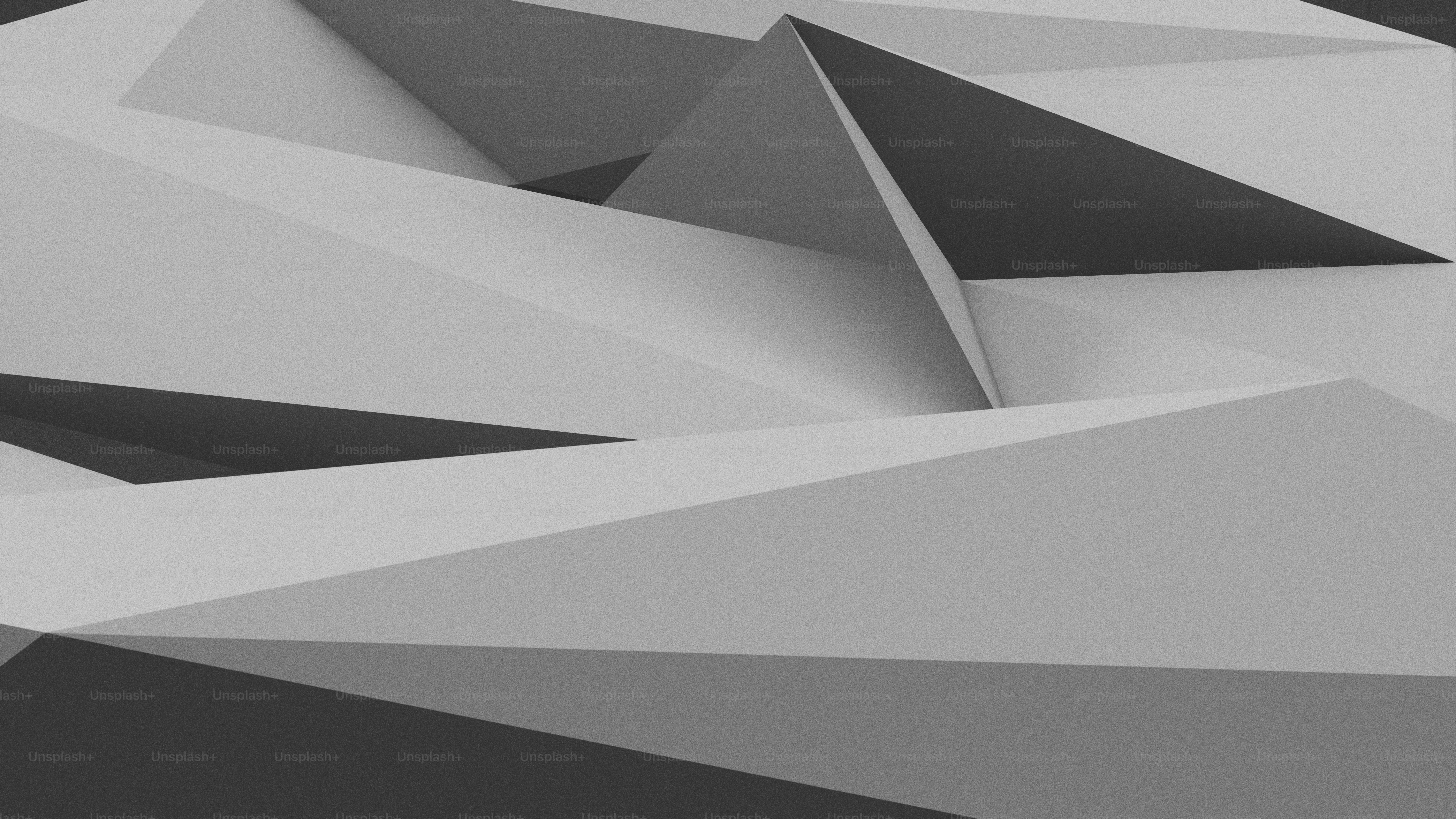 Abstract geometric pattern of overlapping grey triangles with sharp edges and shadows