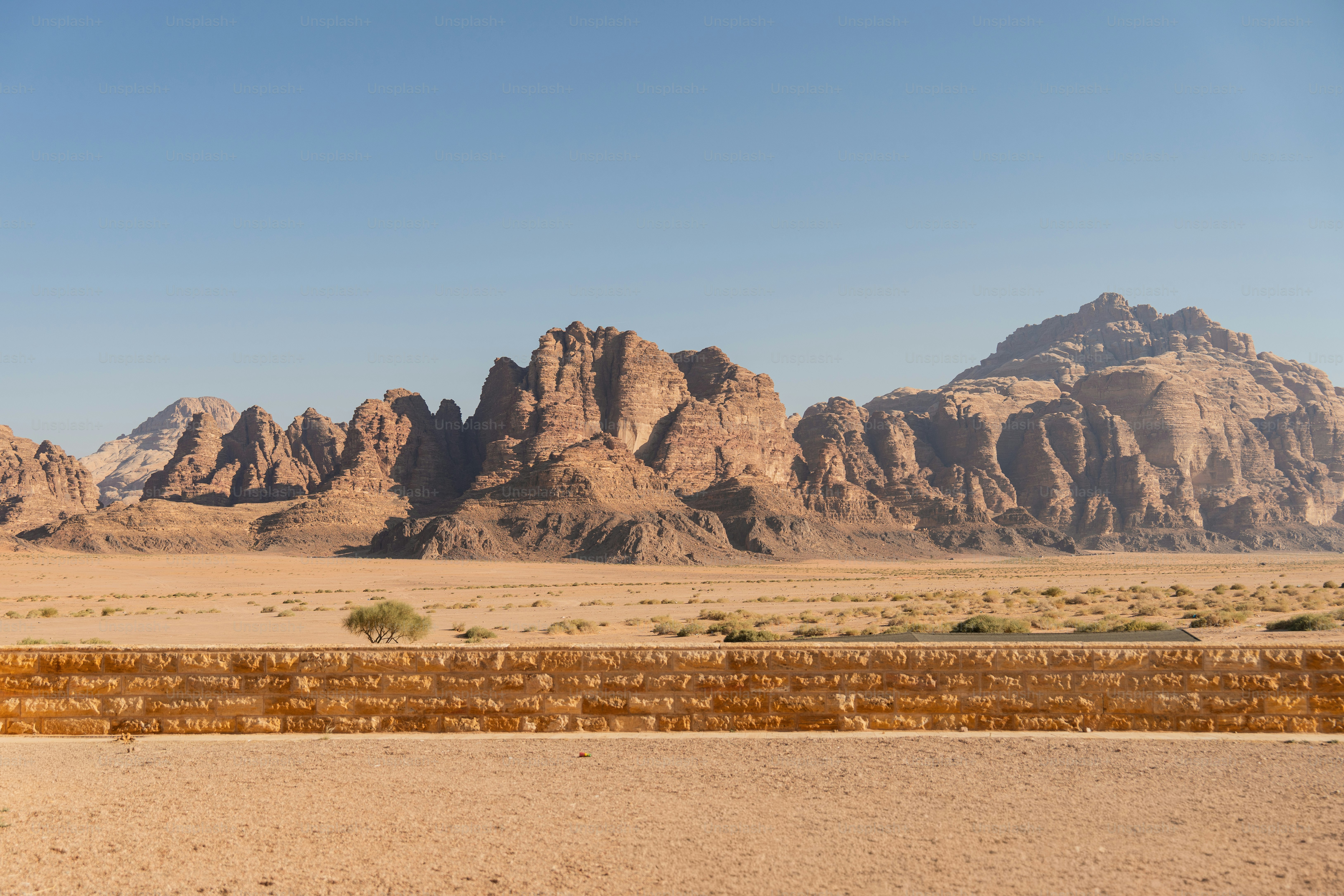 A stone wall in the foreground before desert mountains in Wadi Rum, Jordan
