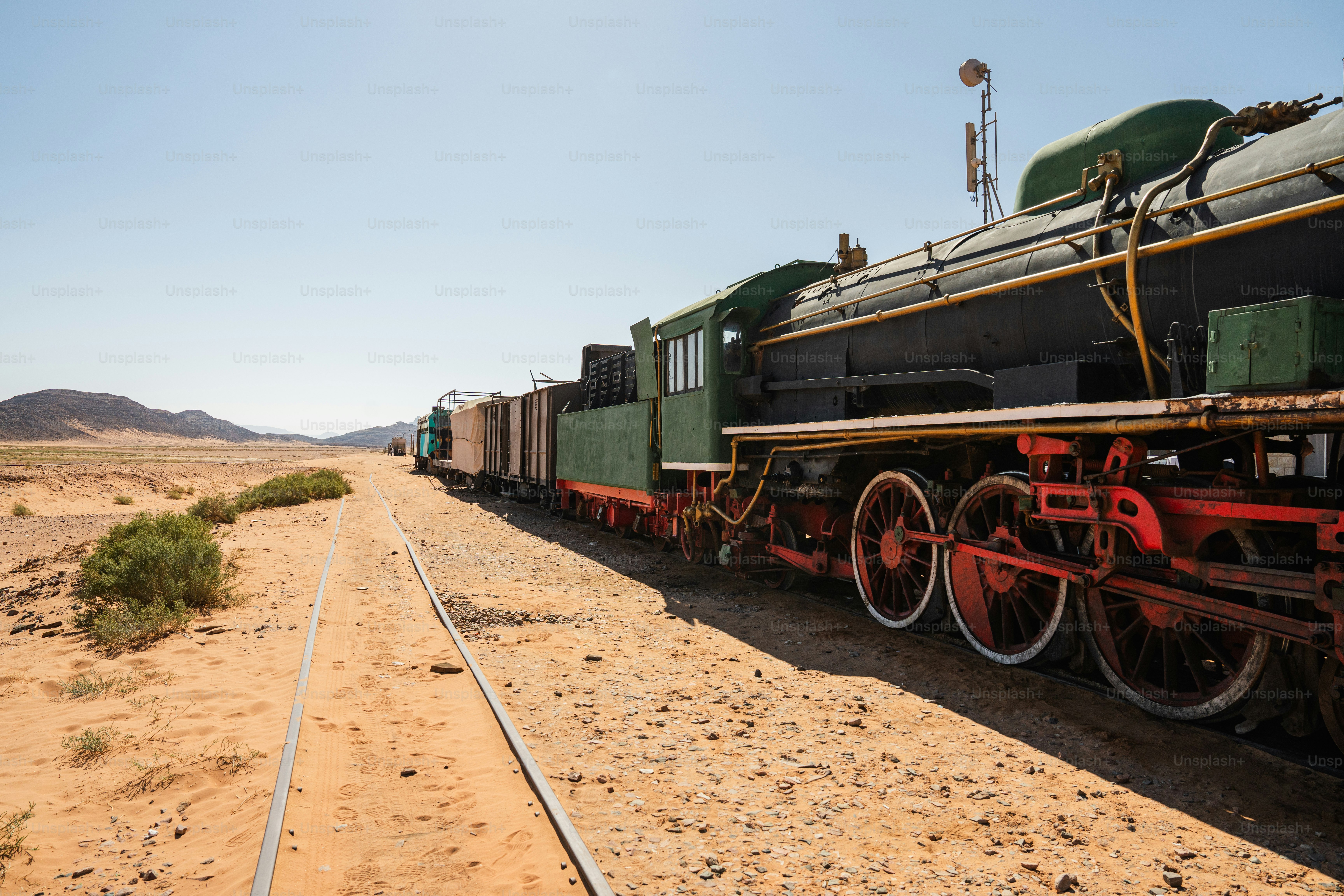 A vintage steam locomotive on tracks in the desert landscape of Rashidiyah, Jordan
