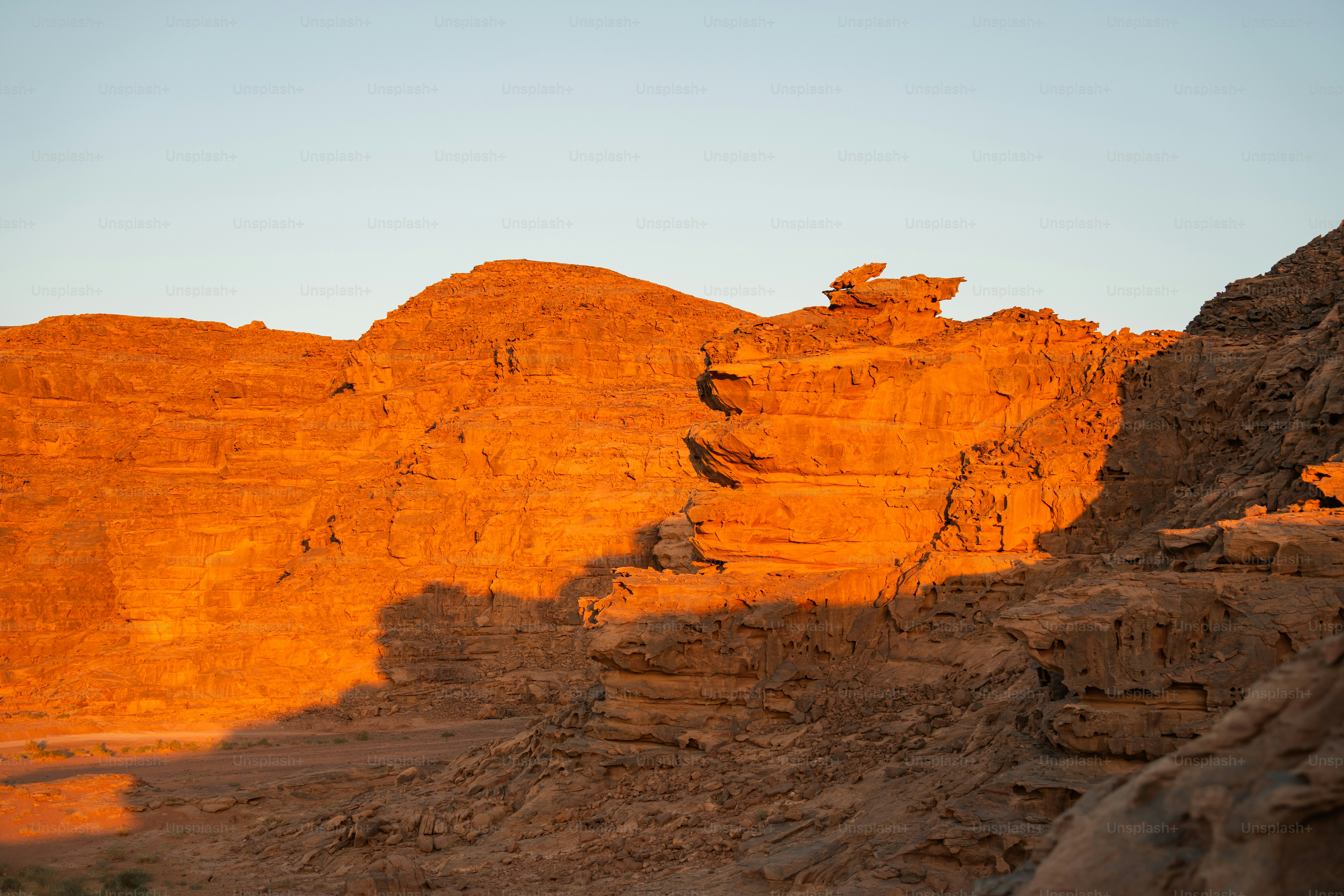 Rugged sandstone cliffs in Wadi Rum, Jordan, illuminated by warm low sun