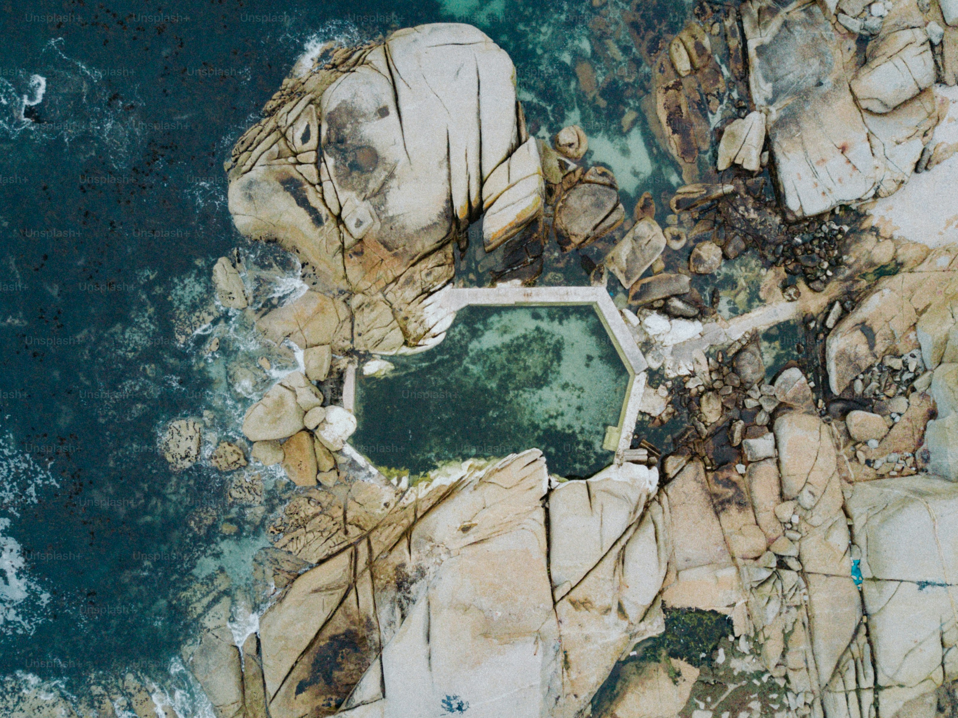 Vista aérea de una poza de marea rodeada de grandes rocas en Ciudad del Cabo