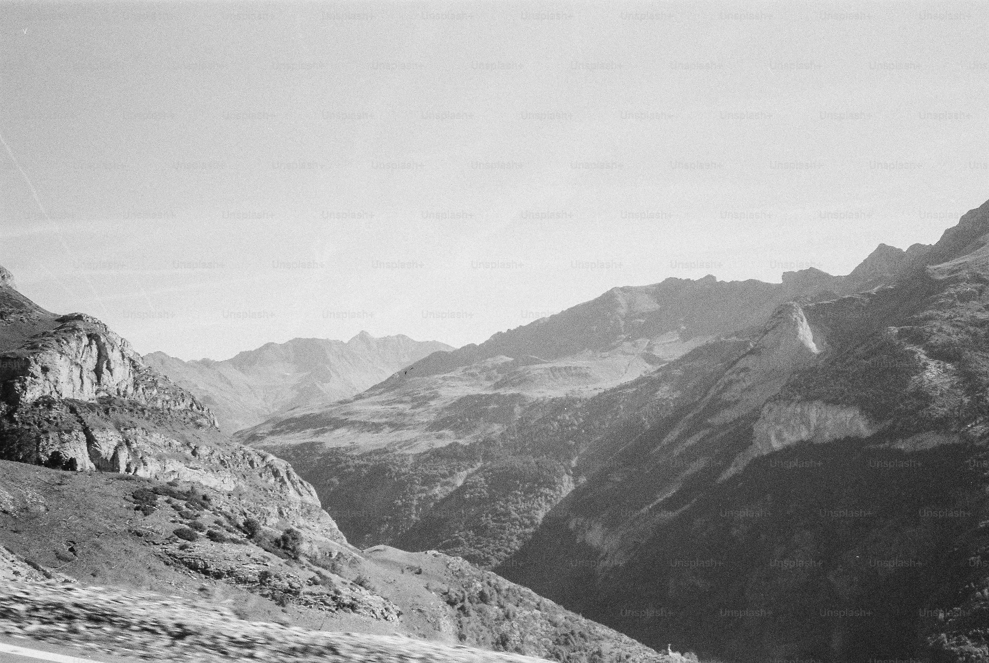 A black and white view of rugged mountain peaks and a deep valley