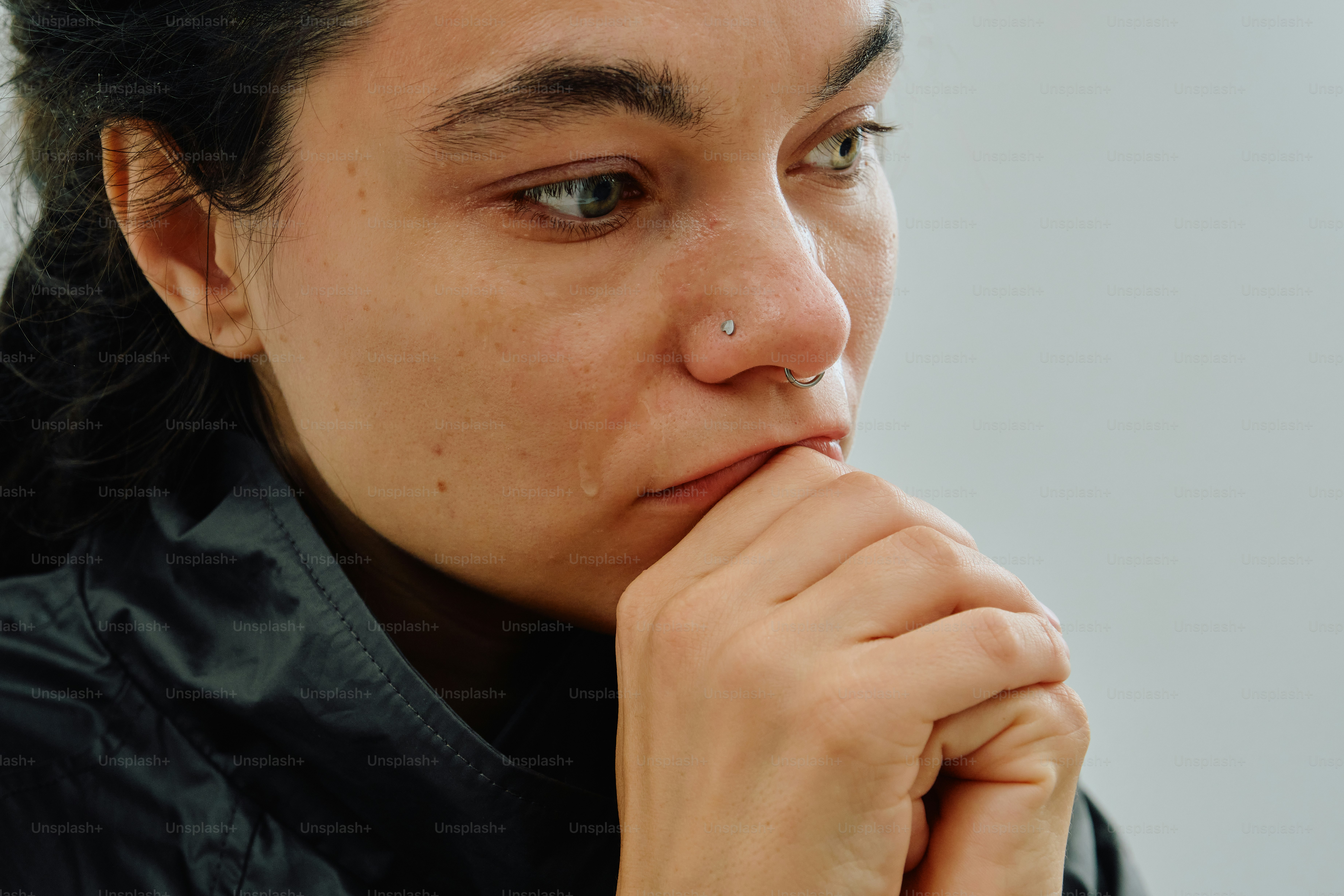 A woman with a nose ring and a tear on her cheek
