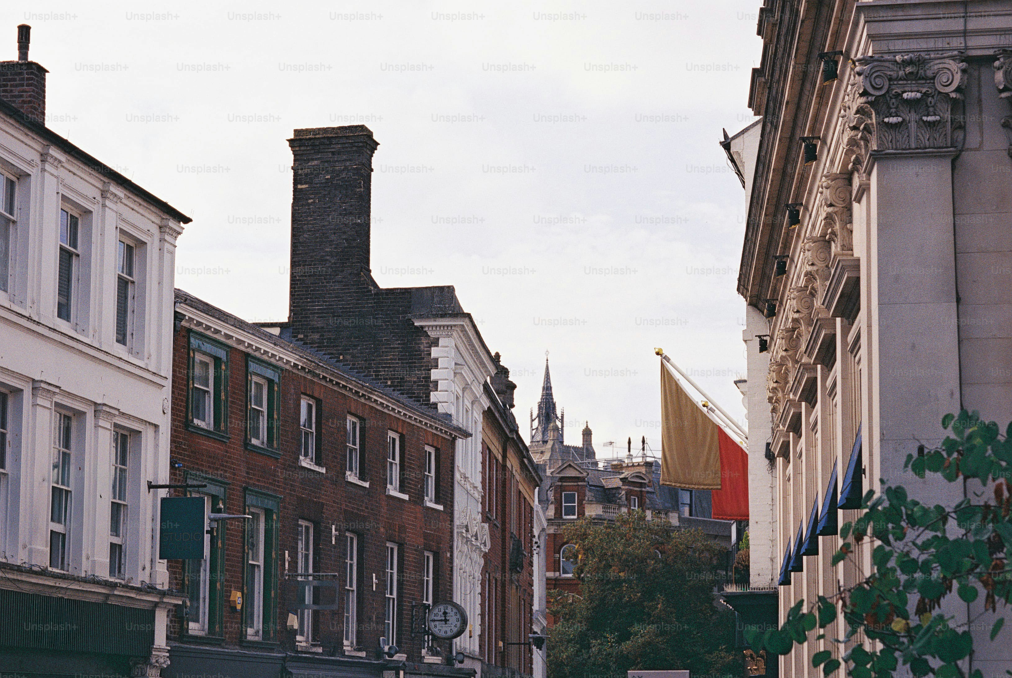 A narrow street lined with historic brick and stone buildings under a pale sky