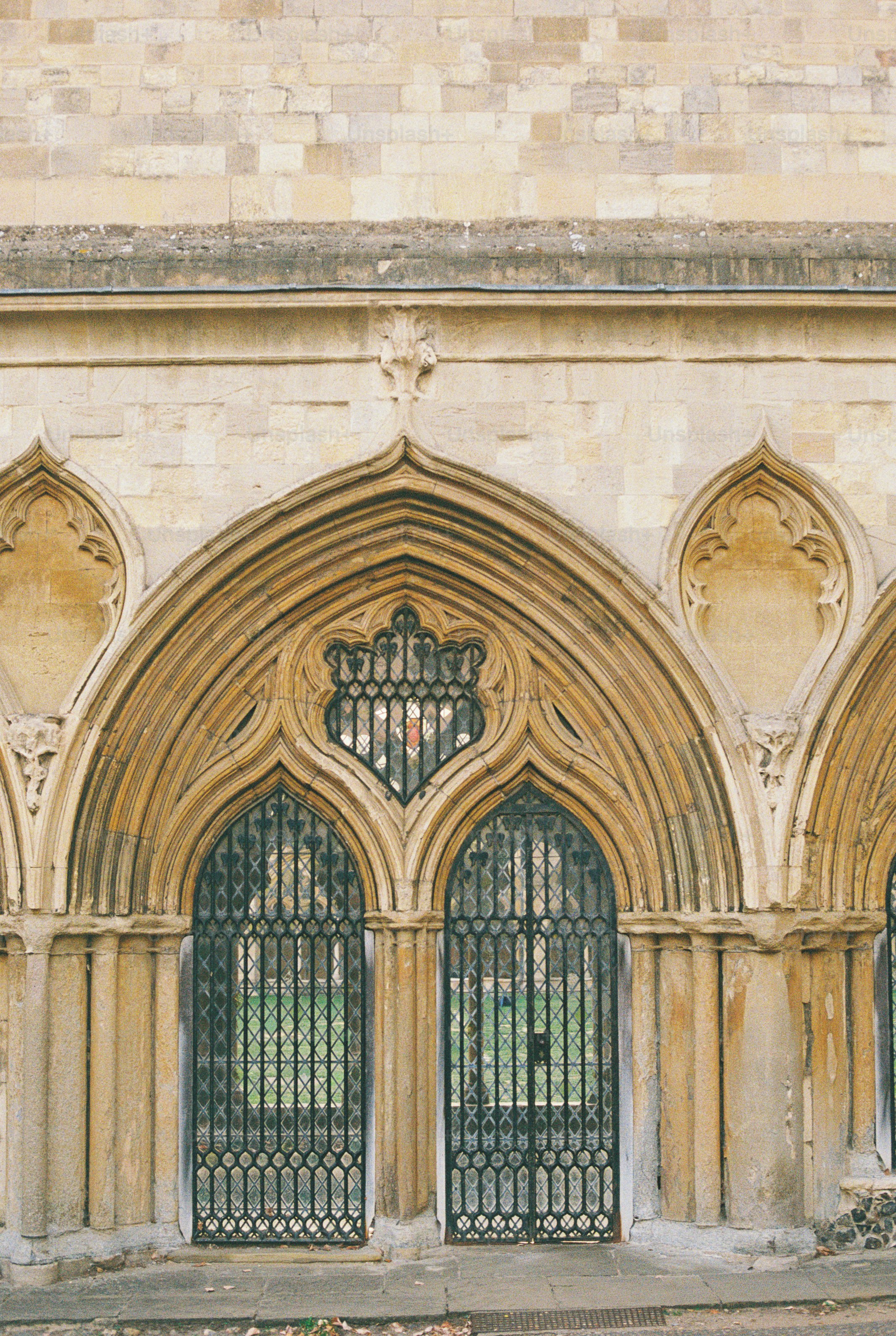 Gothic stone arches with intricate metal grilles over two arched doorways