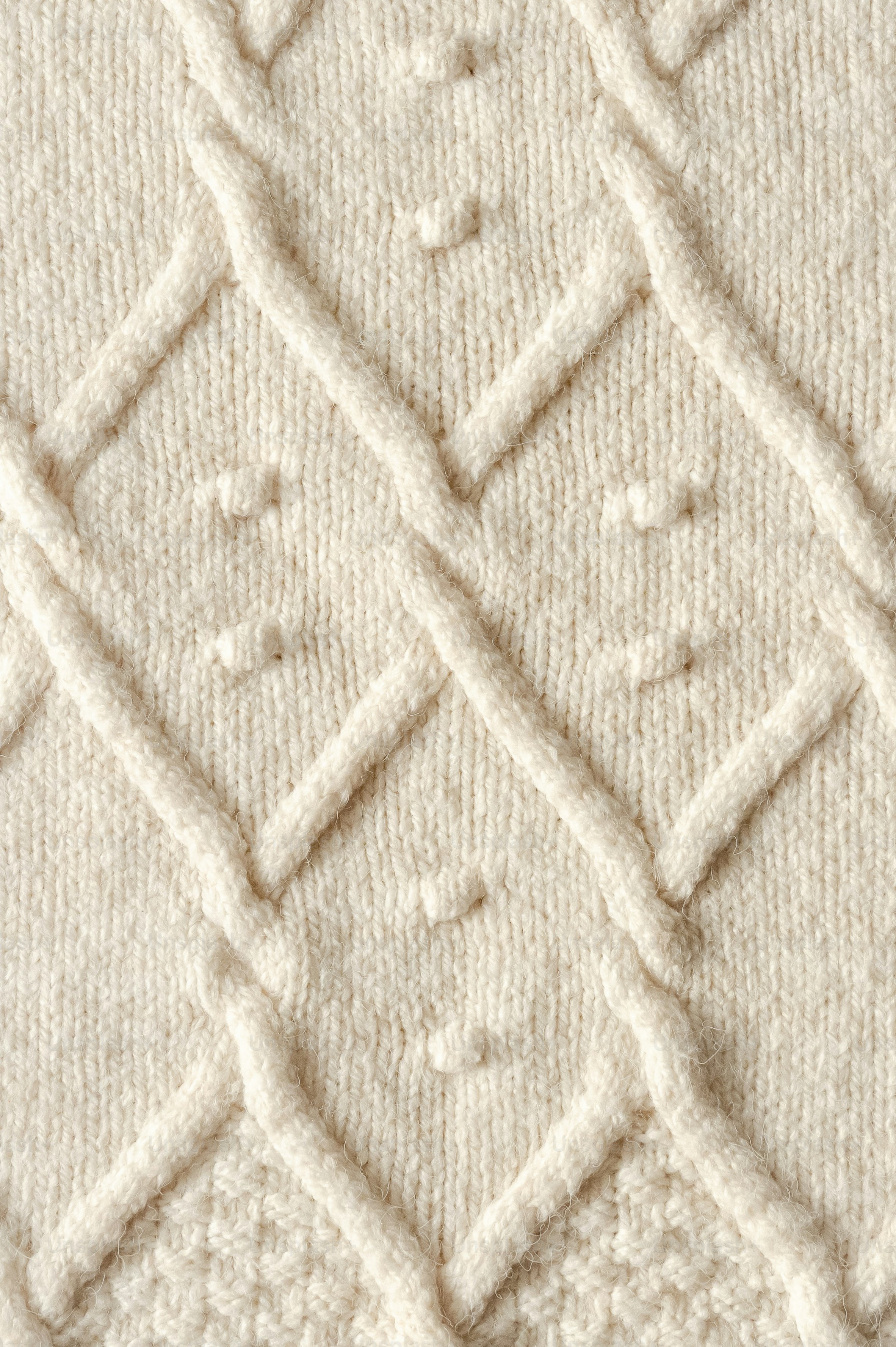 Cream colored wool fabric with a textured diamond cable knit pattern