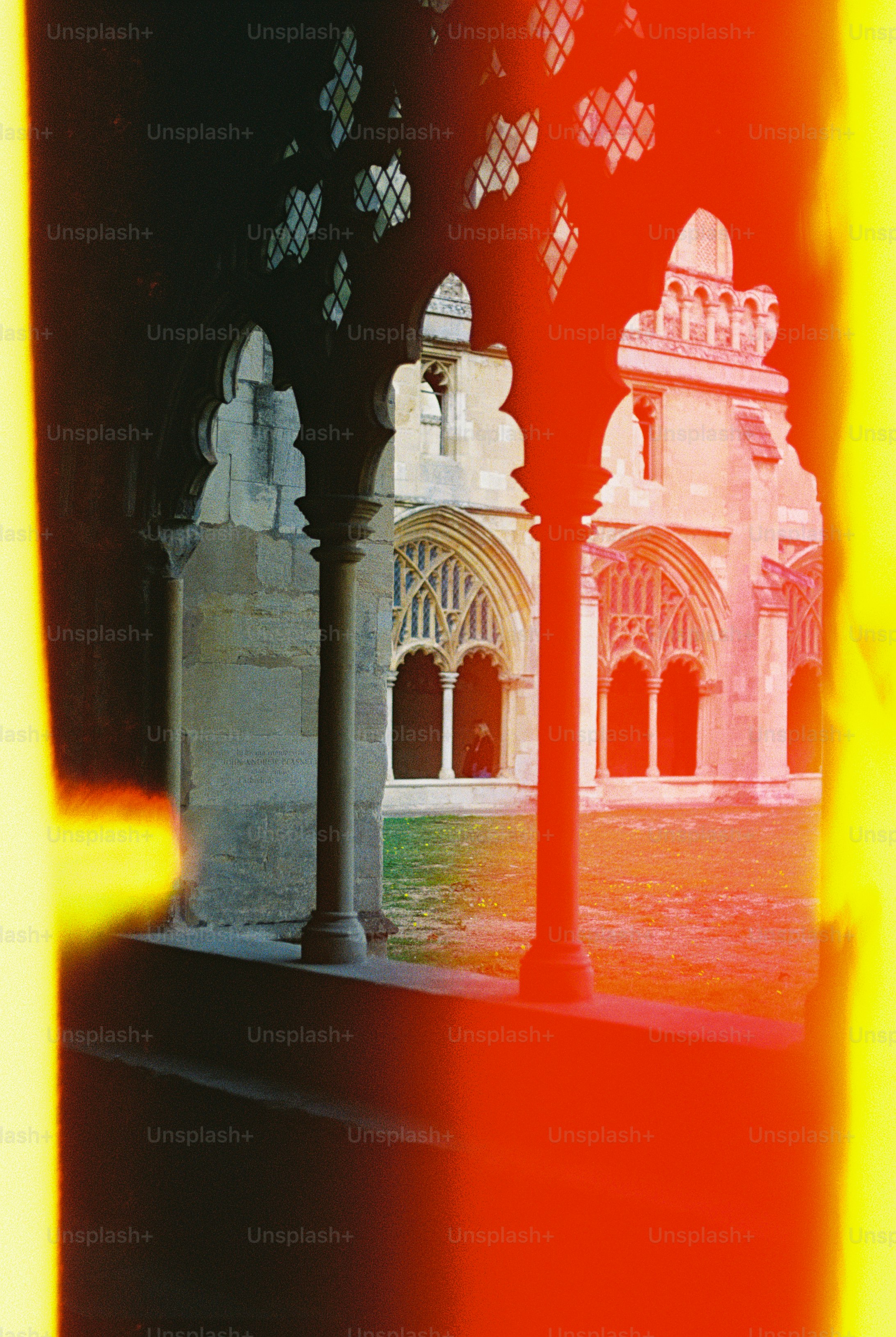 Stone columns and arched windows of a cloister with bright light leaks