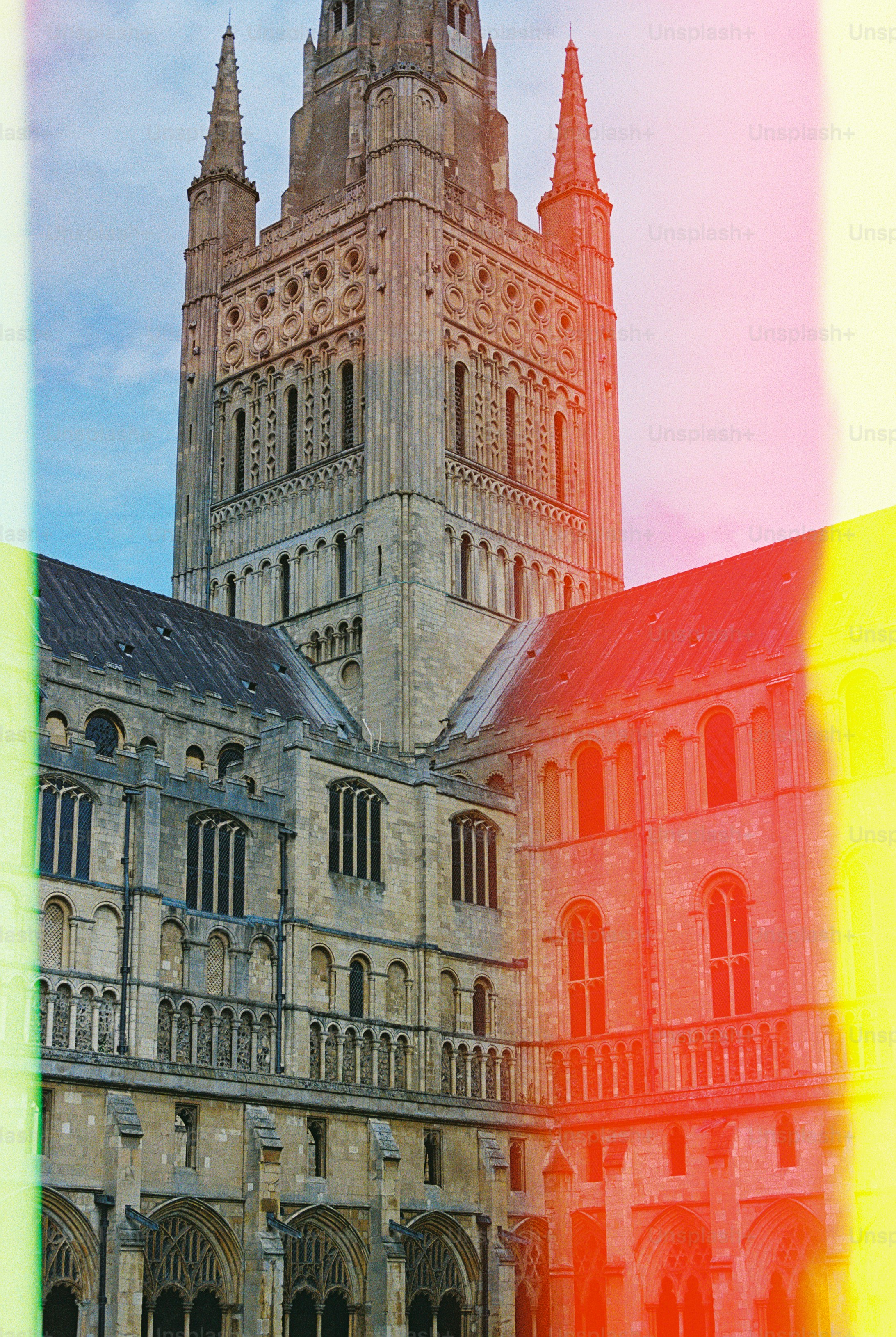 The stone tower and arched windows of a cathedral with colorful light leaks