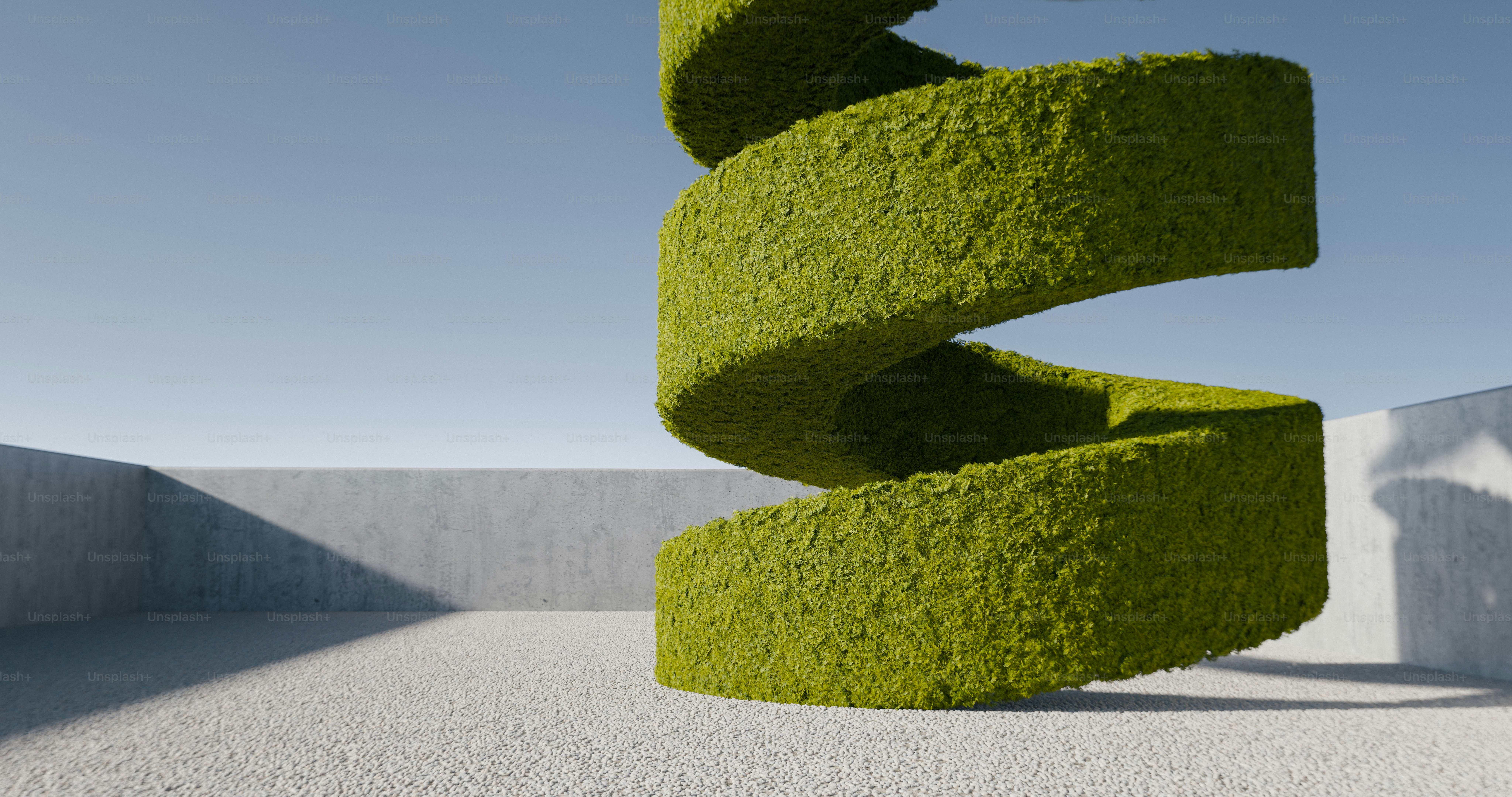A spiral topiary sculpture of green moss on a light grey concrete surface