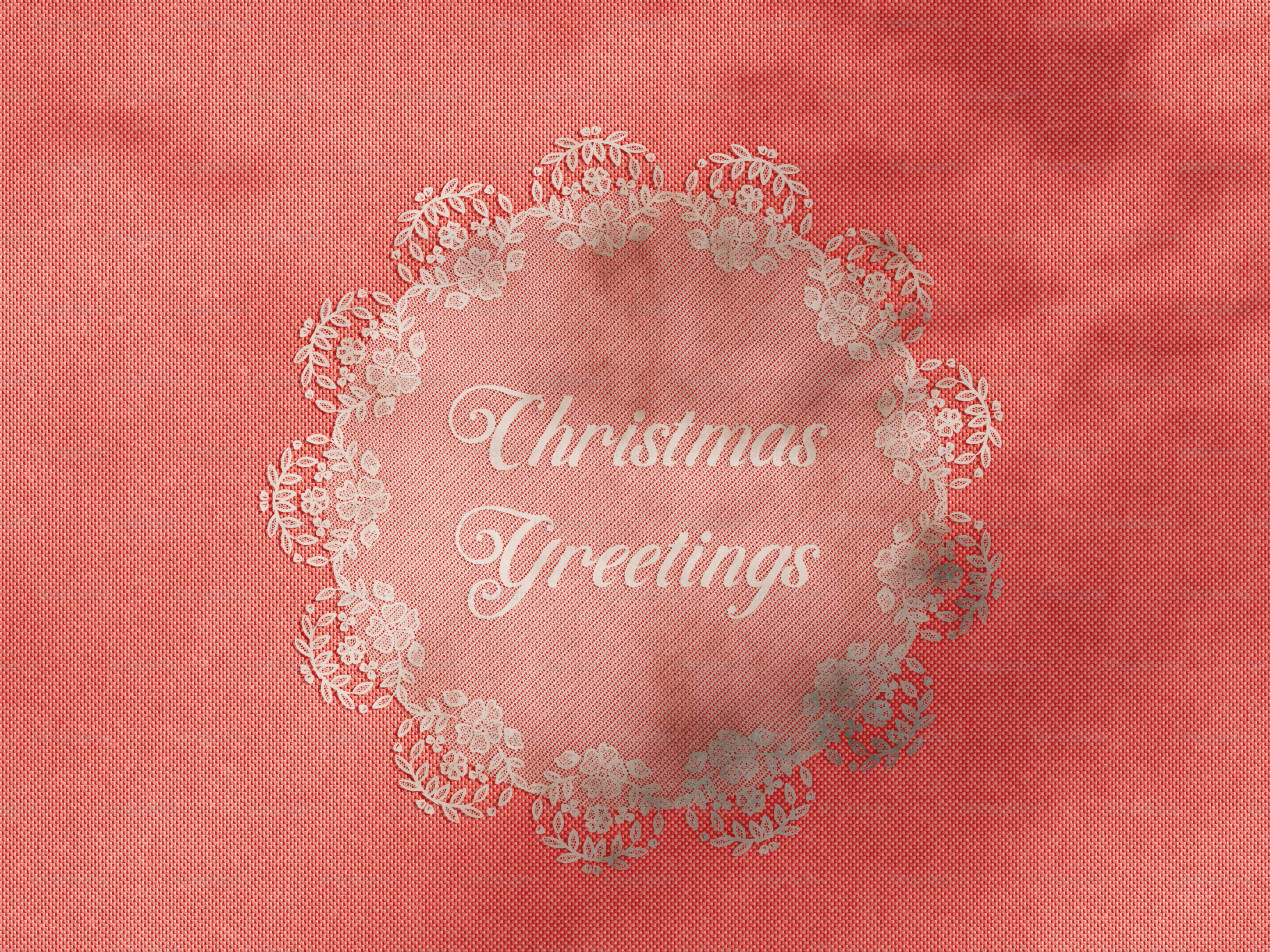 Un marco de tapetes de encaje blanco sobre un fondo texturizado coral rojo con texto de Felicitaciones navideñas
