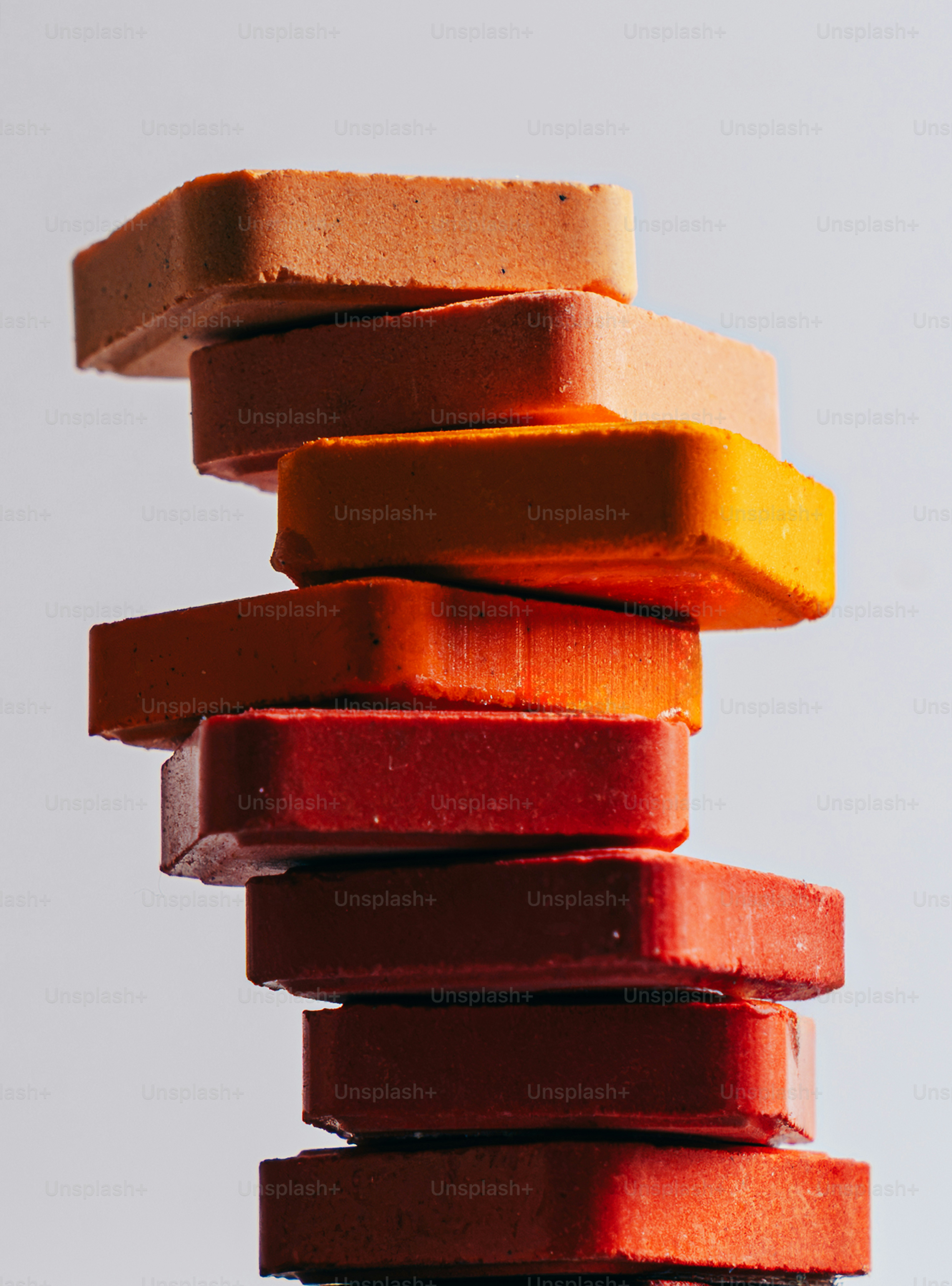 A vertical stack of rectangular blocks in shades of orange and red