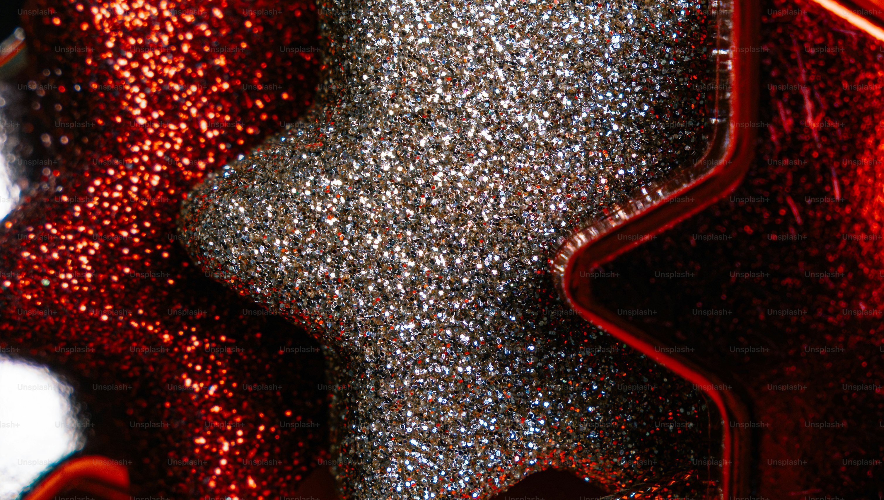 A silver glitter star overlapping a red glitter star in a festive arrangement