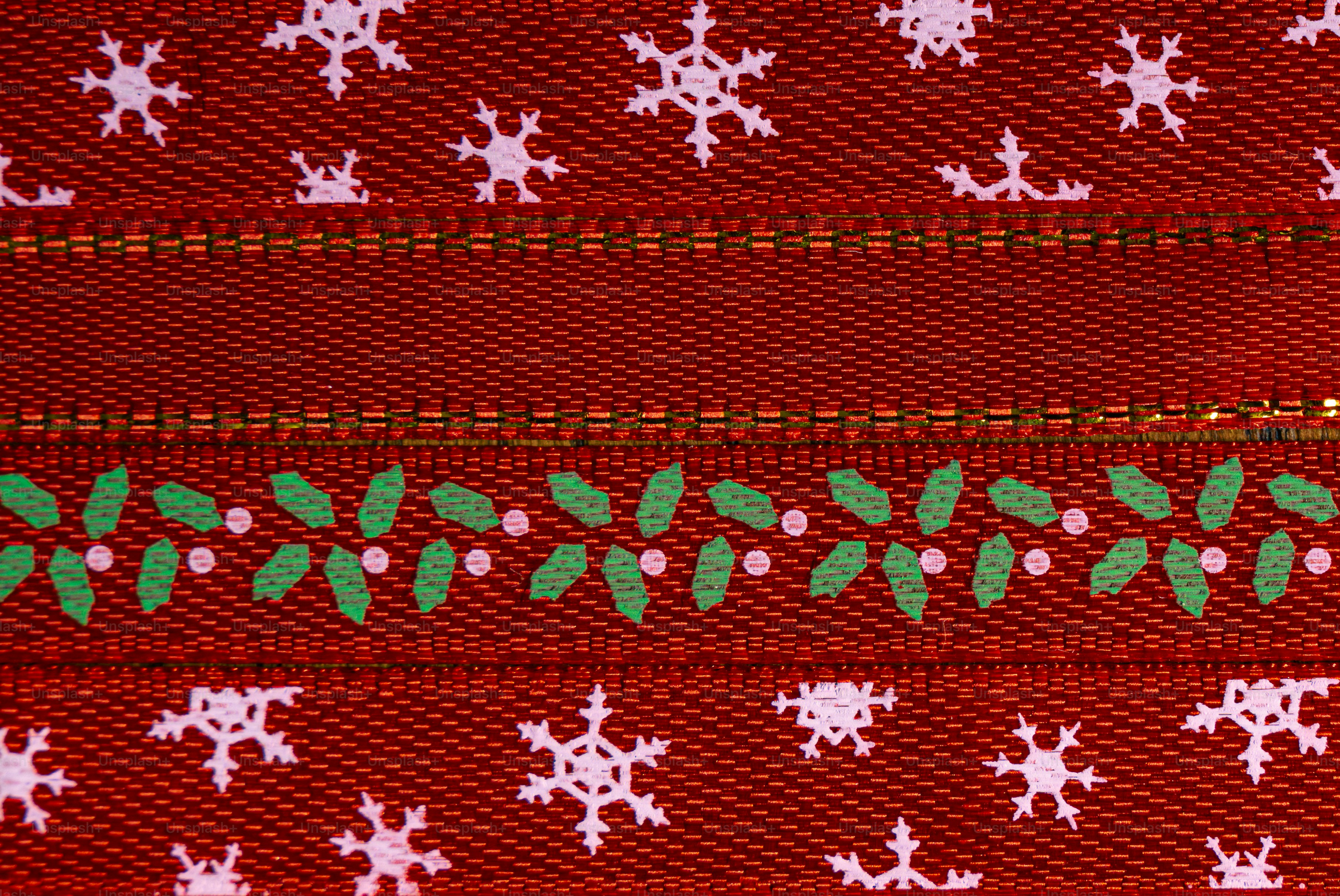 Red fabric ribbon with white snowflake patterns and a green holly leaf border