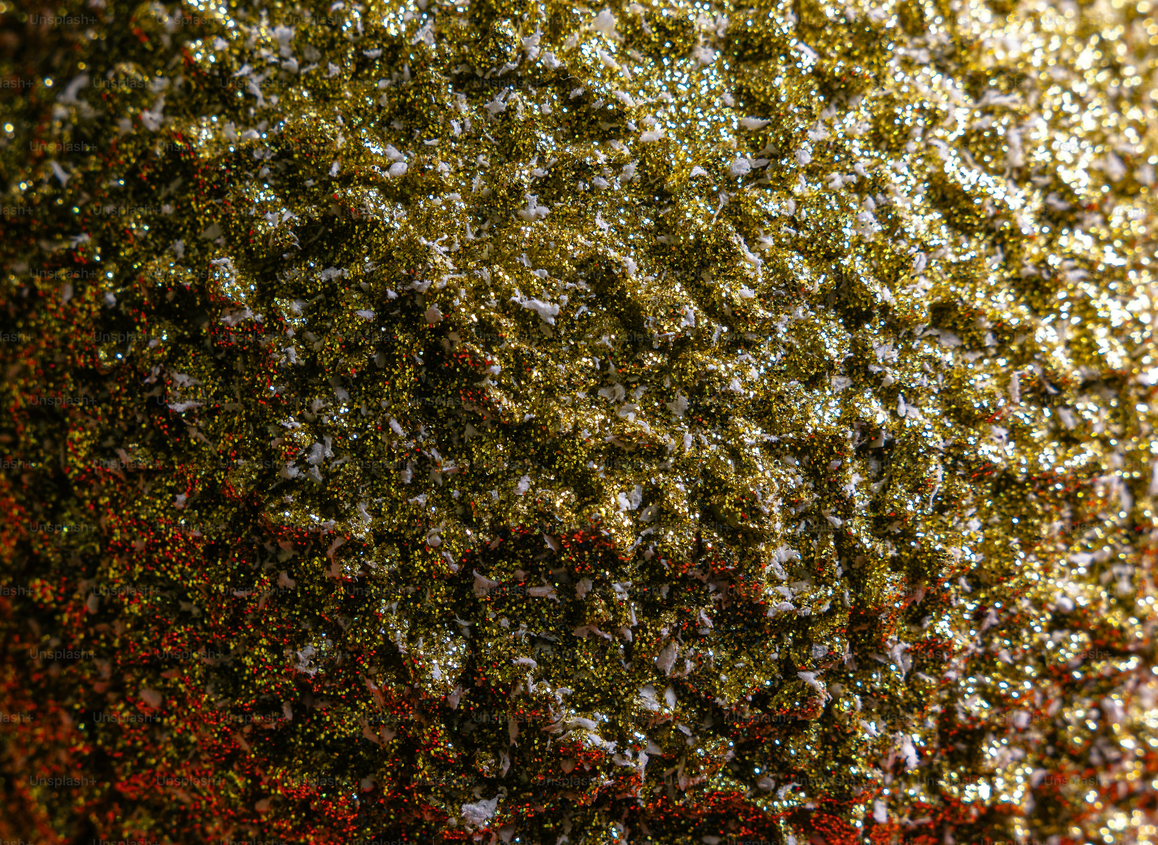 A close-up of a textured surface covered in shimmering gold glitter