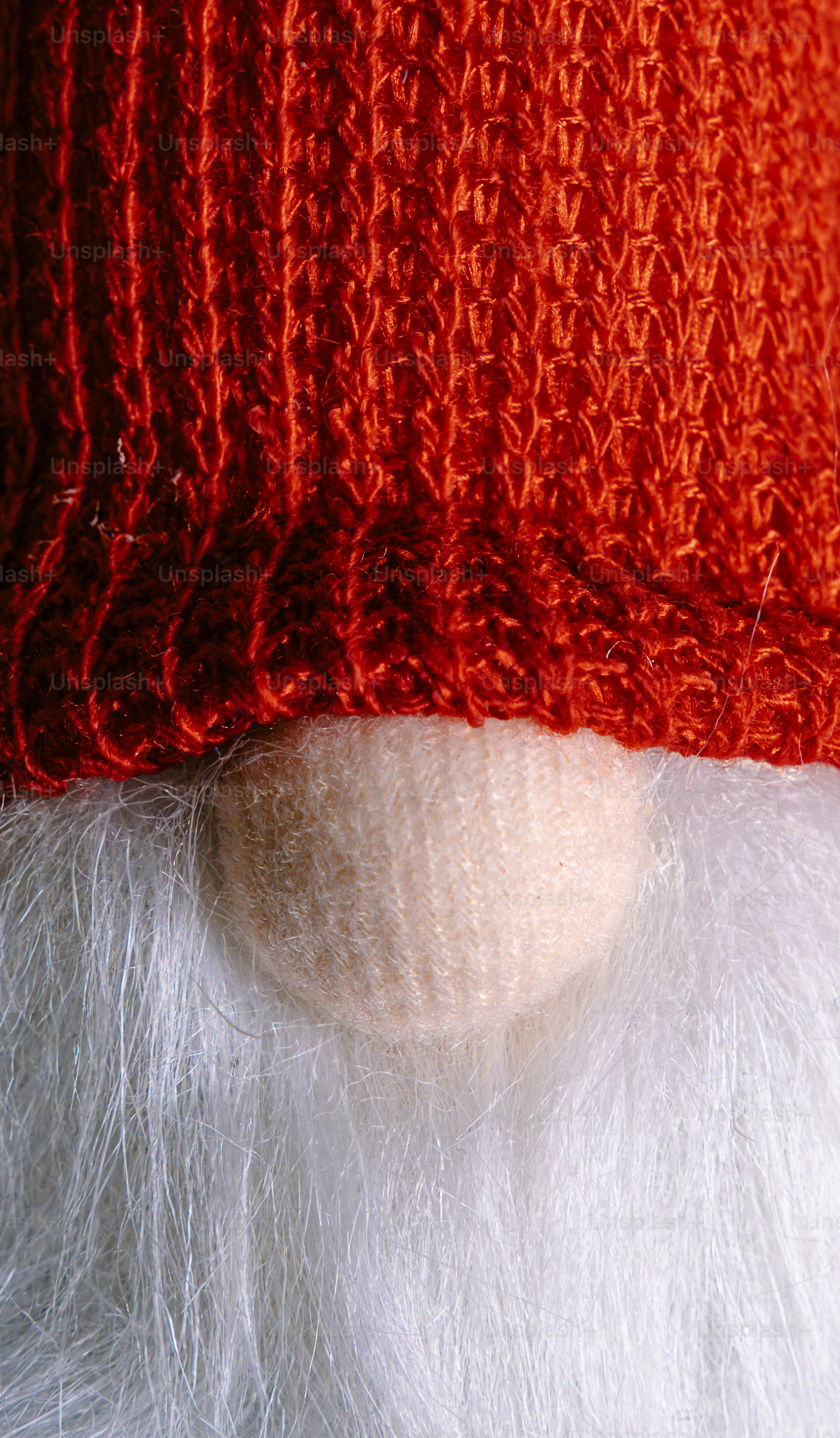 A close-up of a gnome with a red knitted hat and white beard