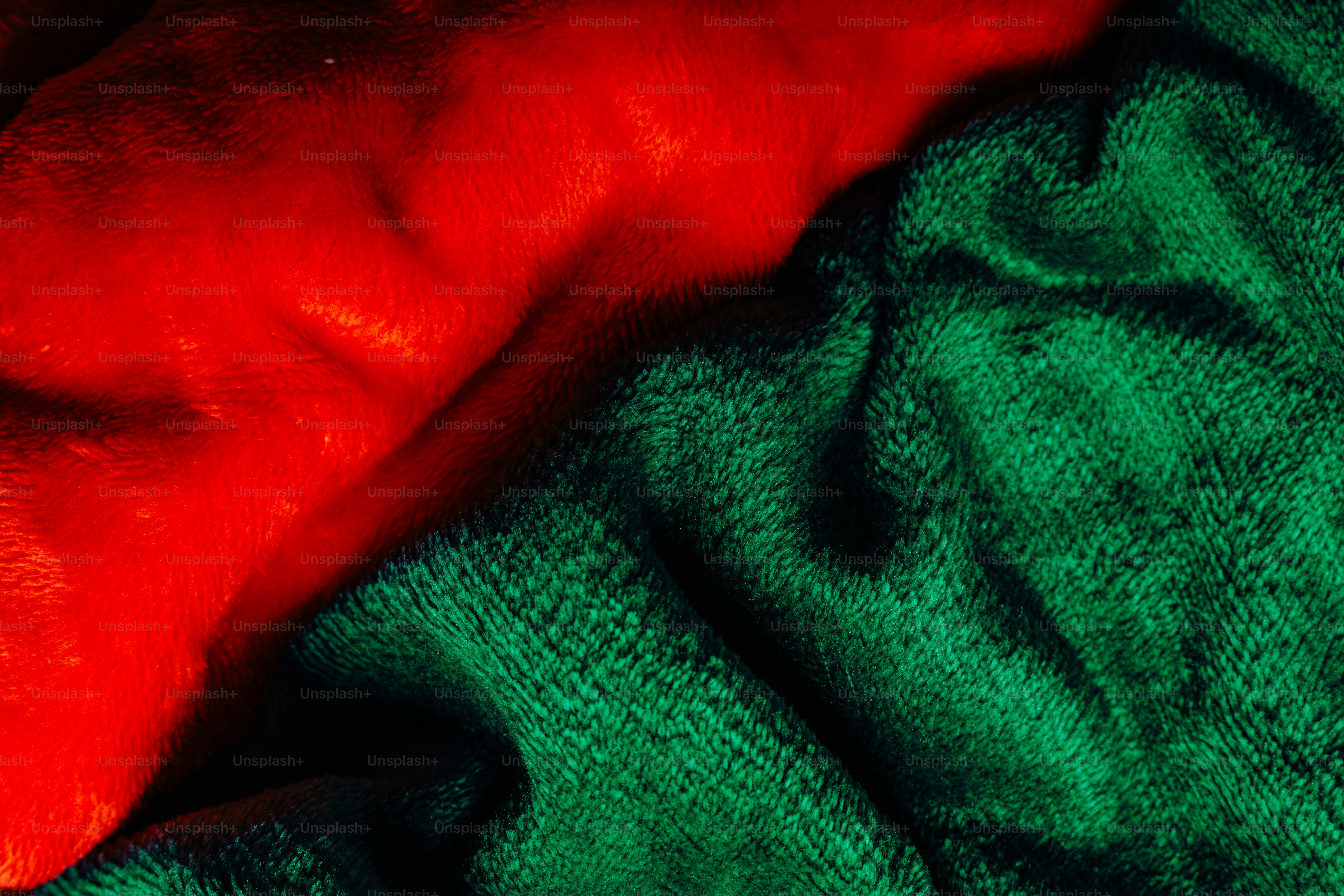 Soft red and green plush fabric with deep folds and shadows