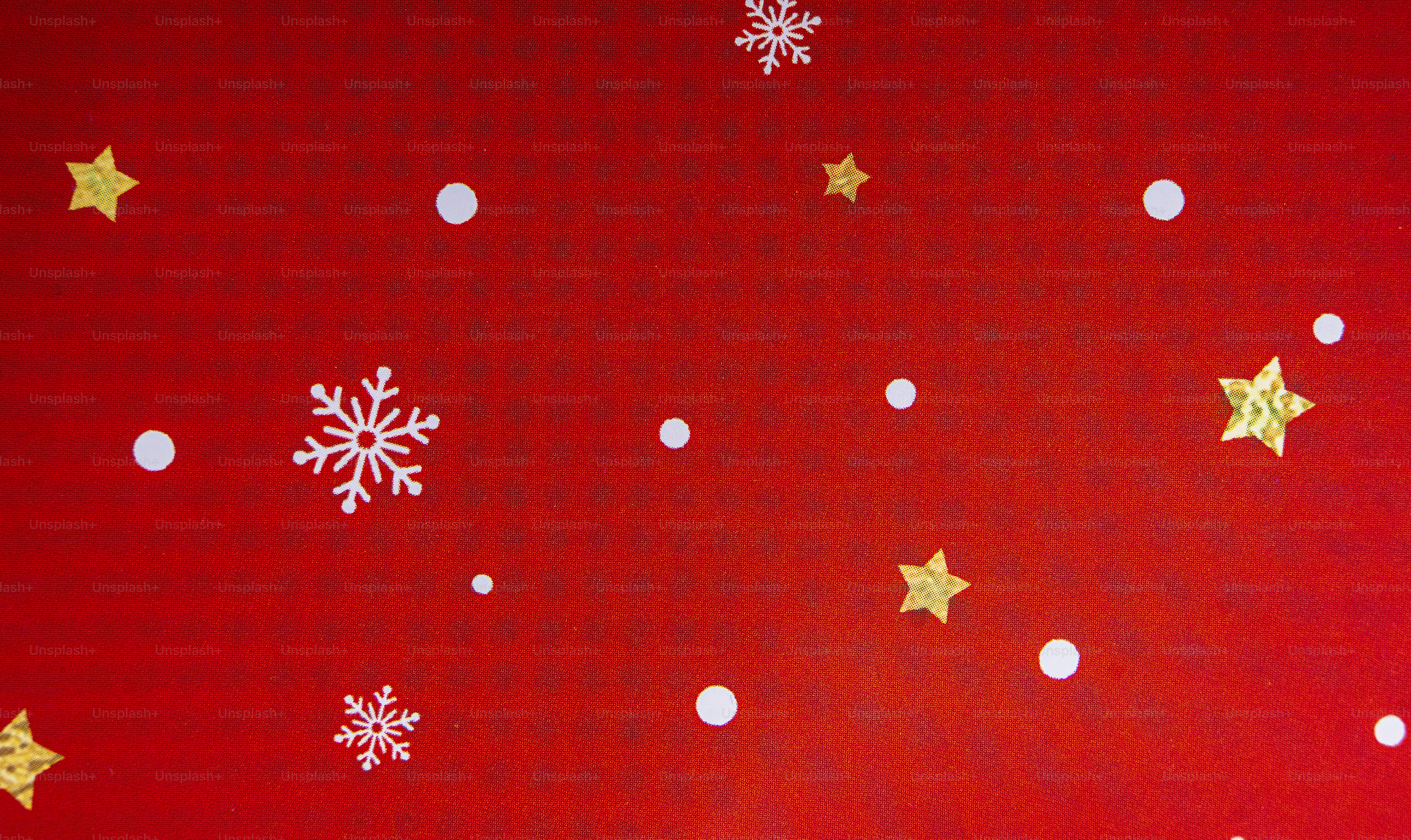 White snowflakes and gold stars on a vibrant red background