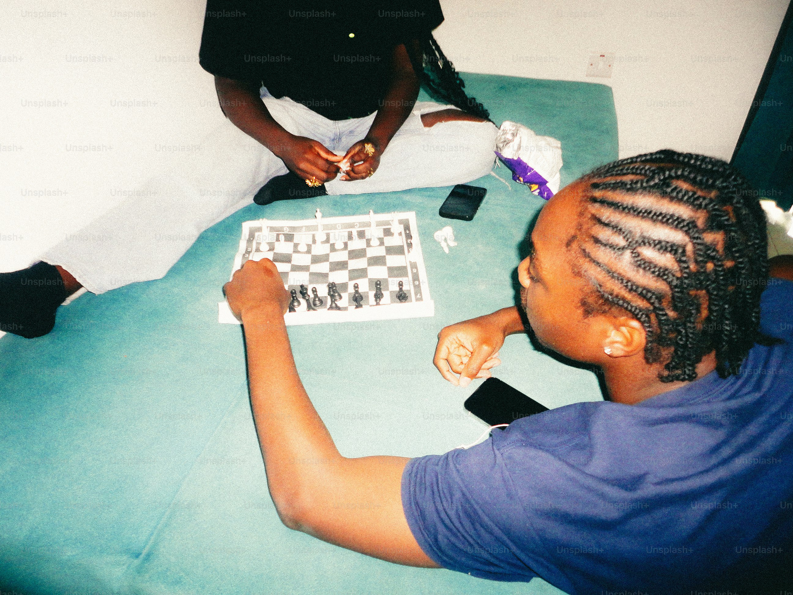 People playing chess on teal surface - Photo on Unsplash+