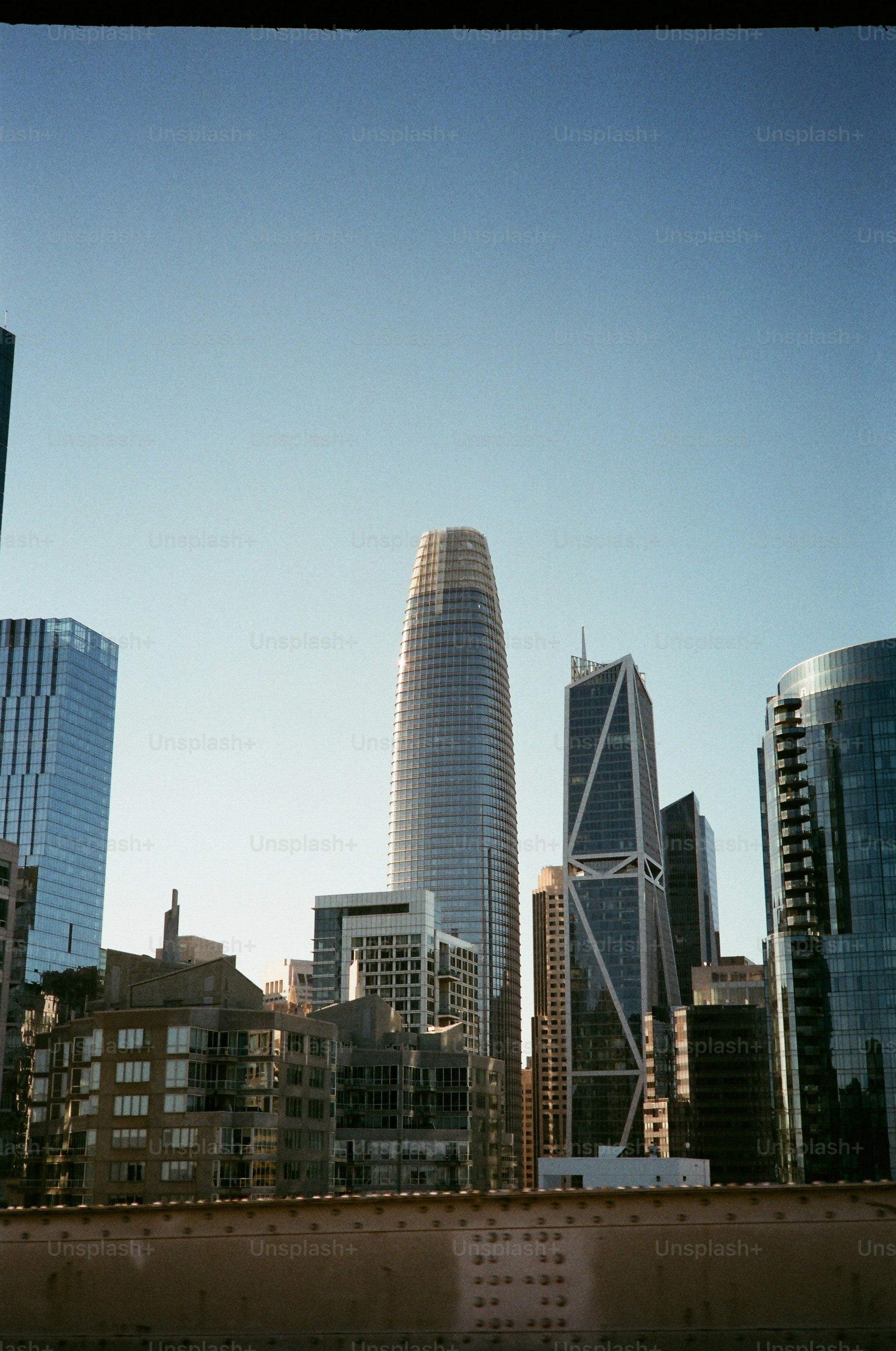 A Salesforce Tower e os arranha-céus de vidro ao redor no horizonte de São Francisco sob um céu azul claro