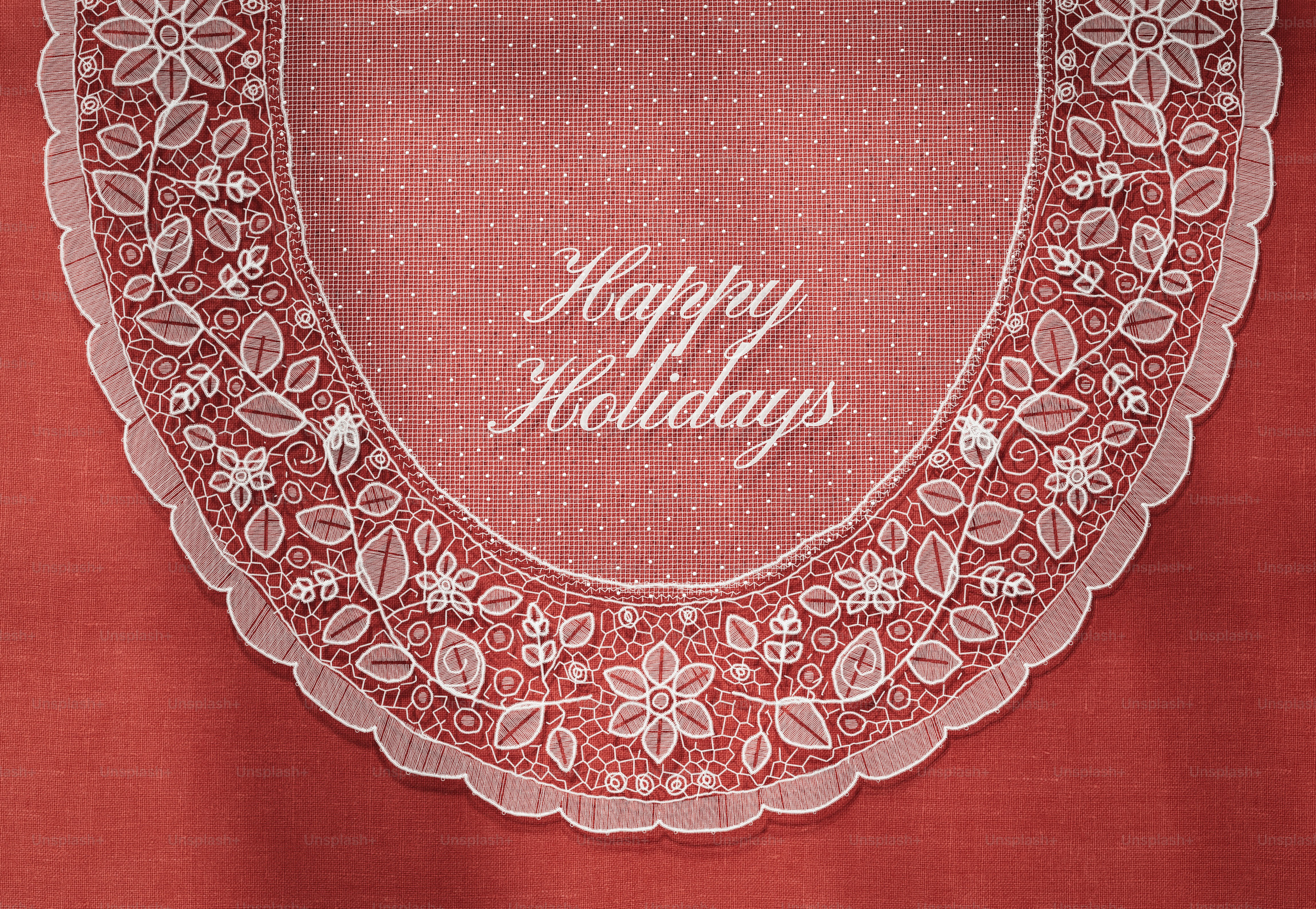 White lace doily with floral patterns on a textured red background