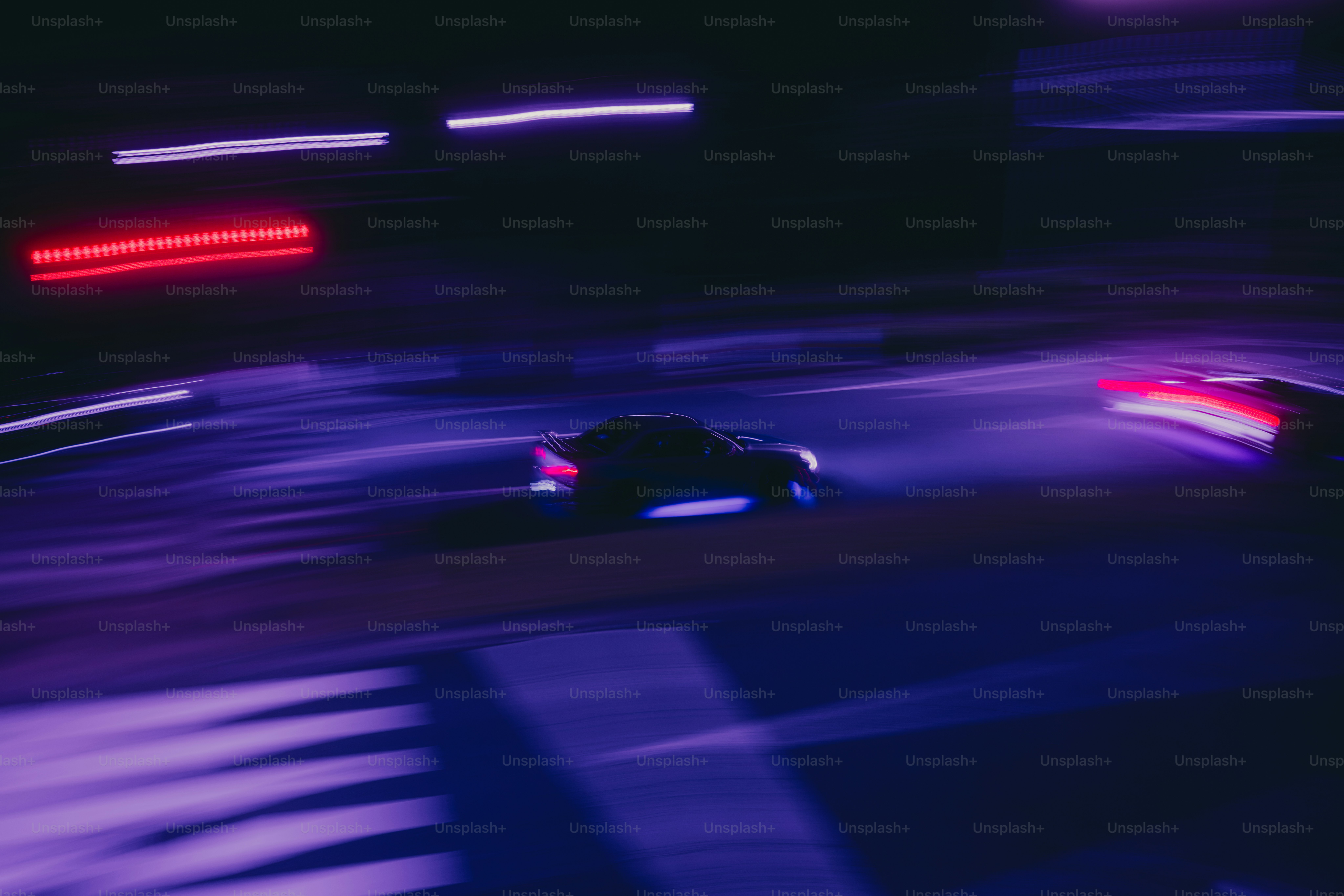 A car driving on a city street at night with long exposure light trails