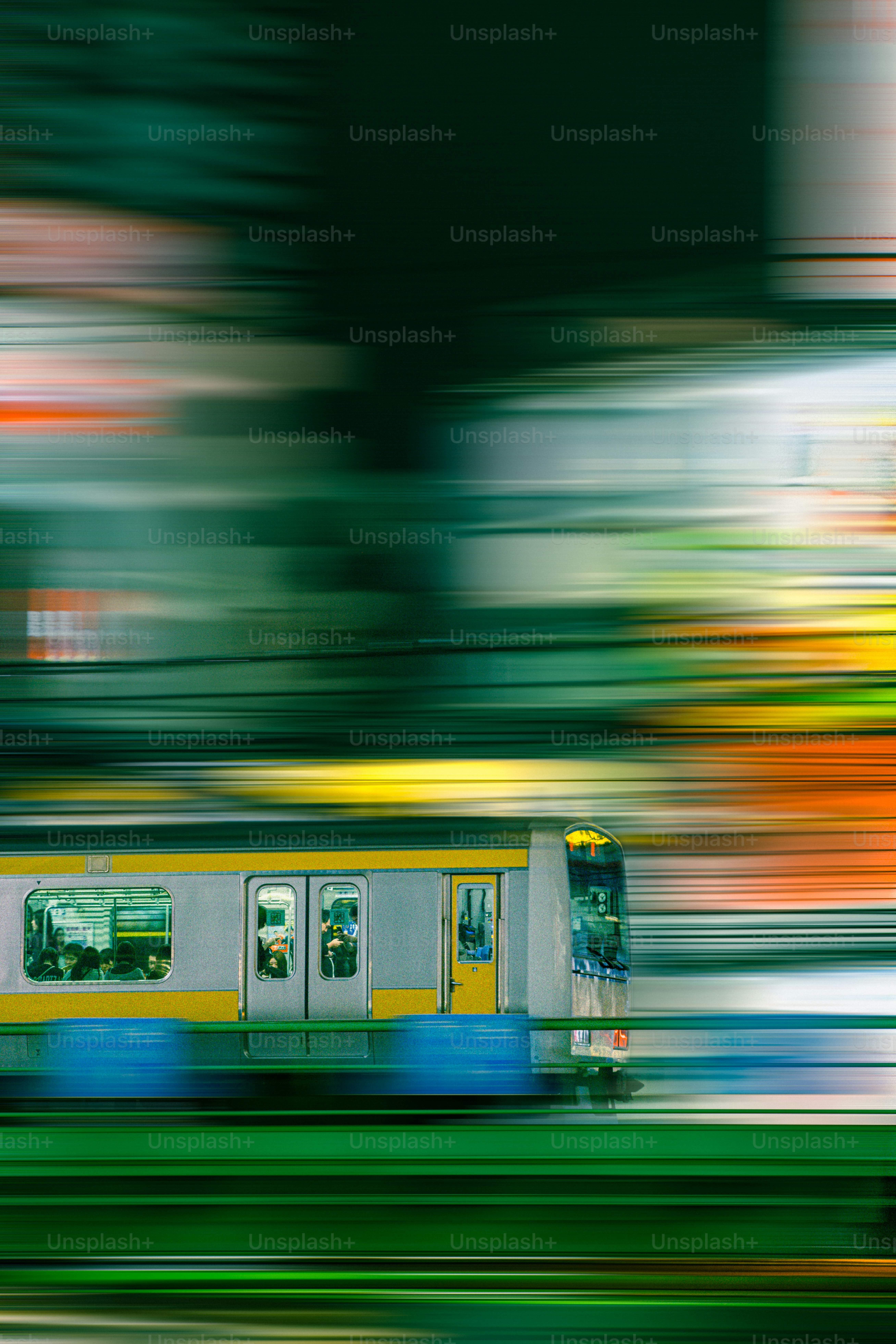 A commuter train moving at high speed past a blurred urban background