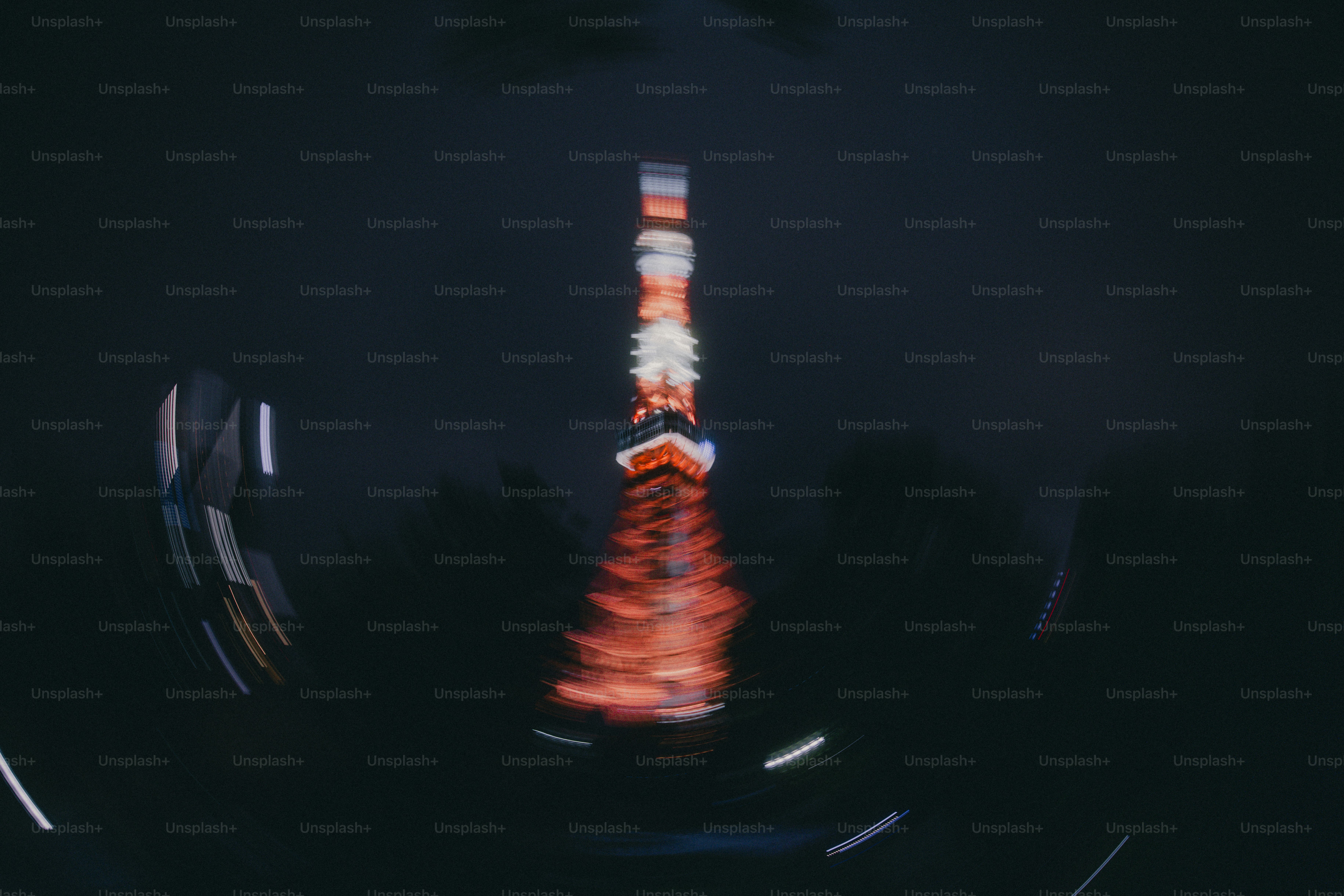 The Tokyo Tower illuminated at night with a motion blur effect in Minato City