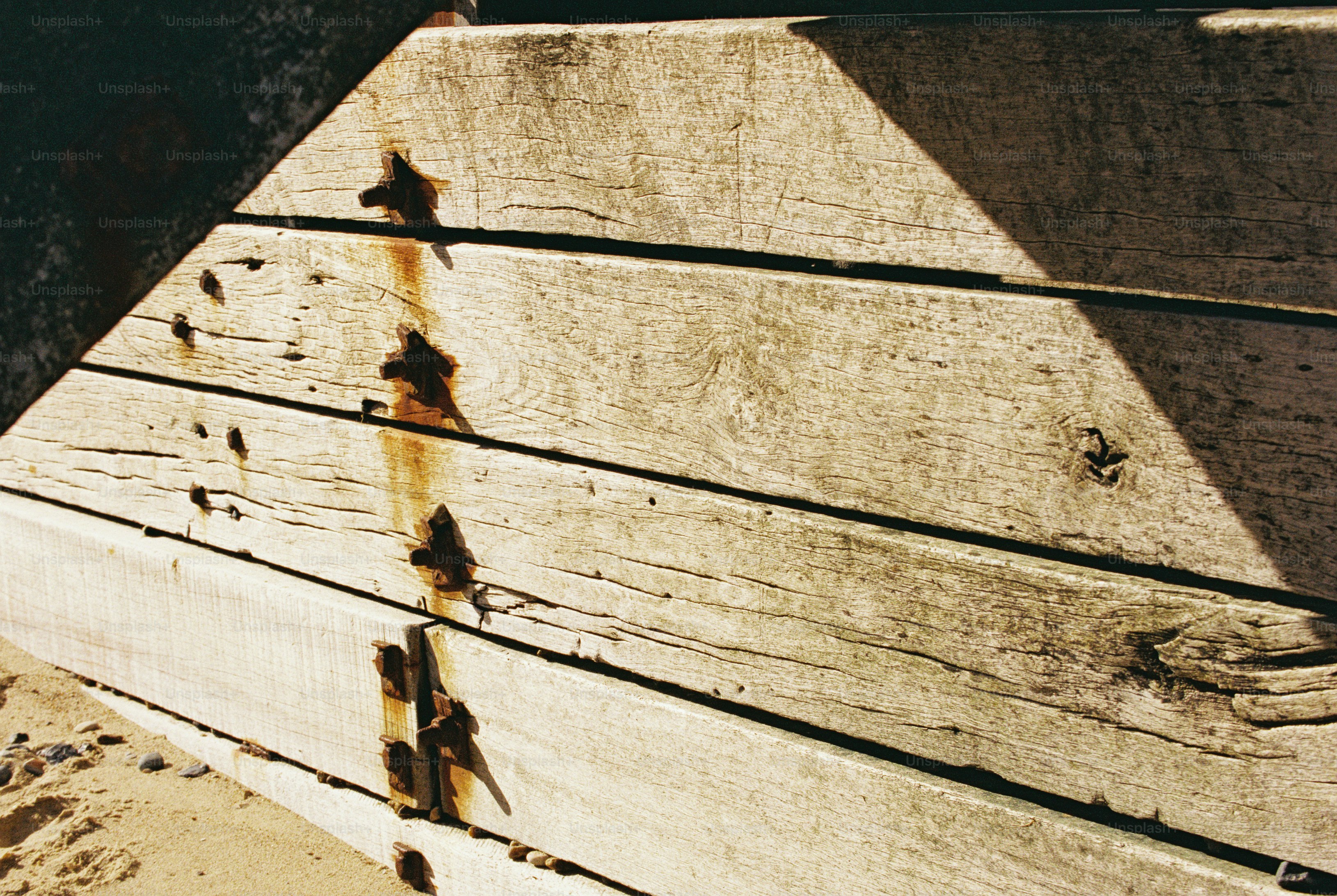 Weathered timber planks with rusted spikes - Photo on Unsplash+