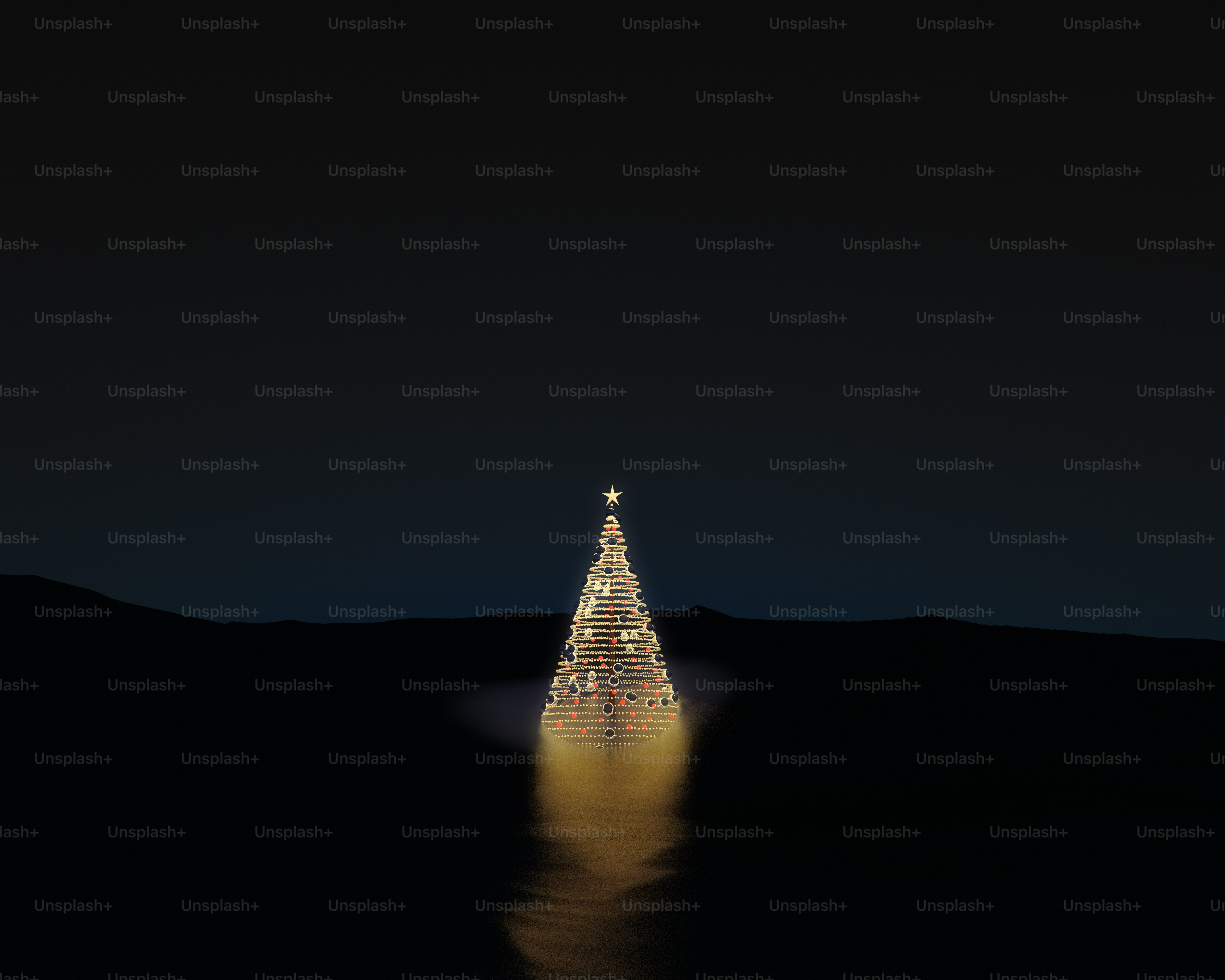 A glowing Christmas tree with ornaments on a dark landscape at night