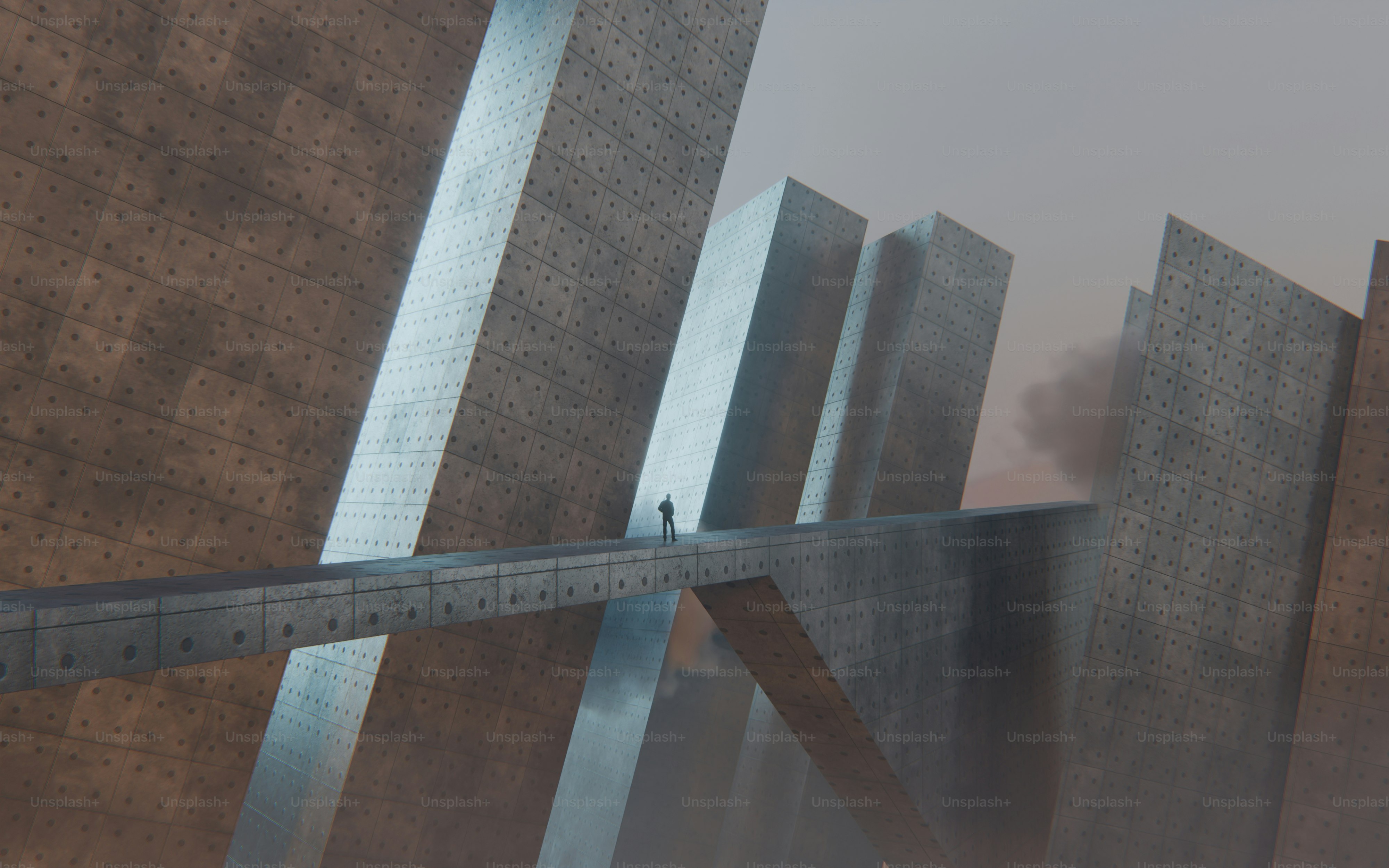 A person on a narrow concrete bridge between towering geometric structures