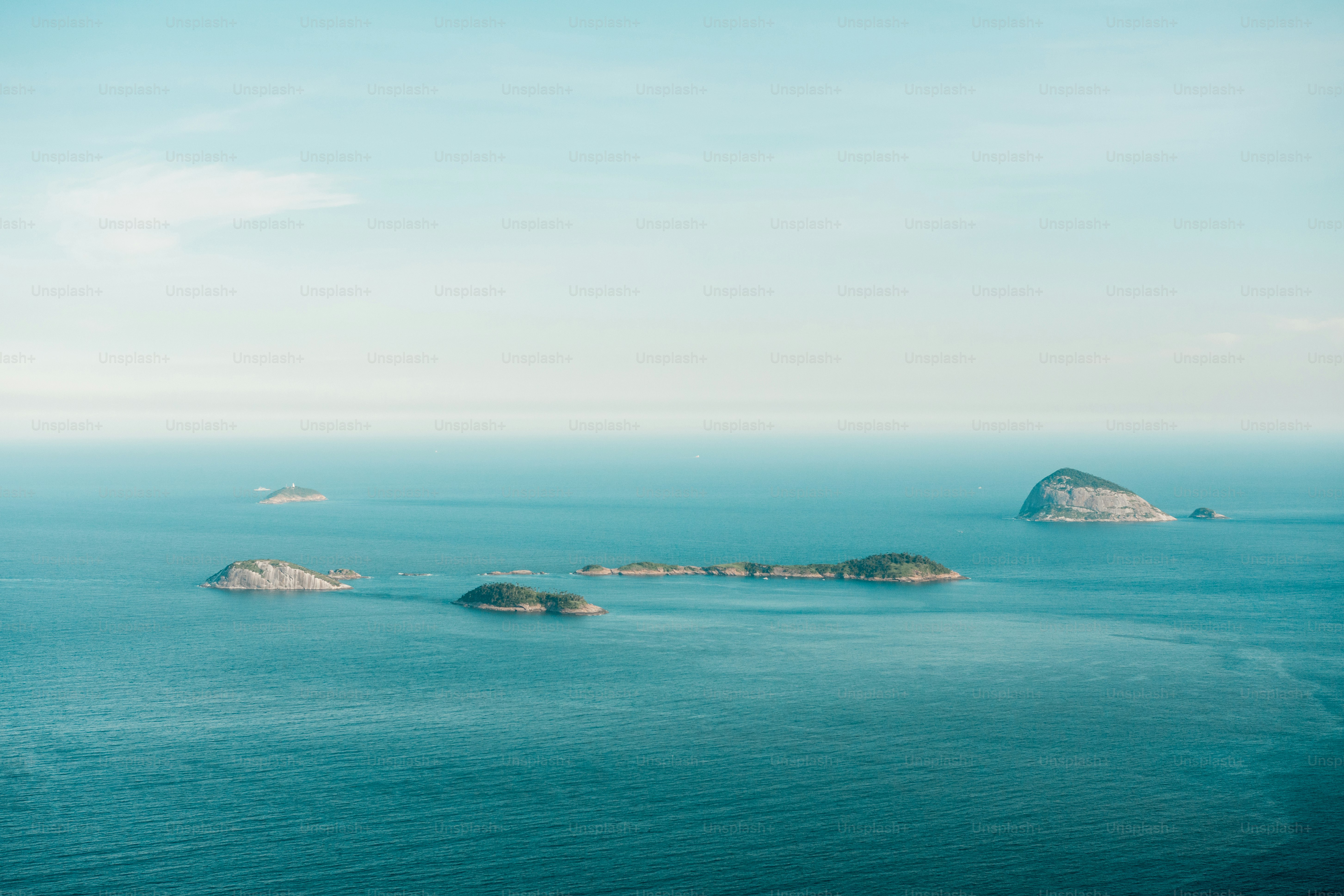 Small rocky islands with green vegetation scattered across a calm blue ocean