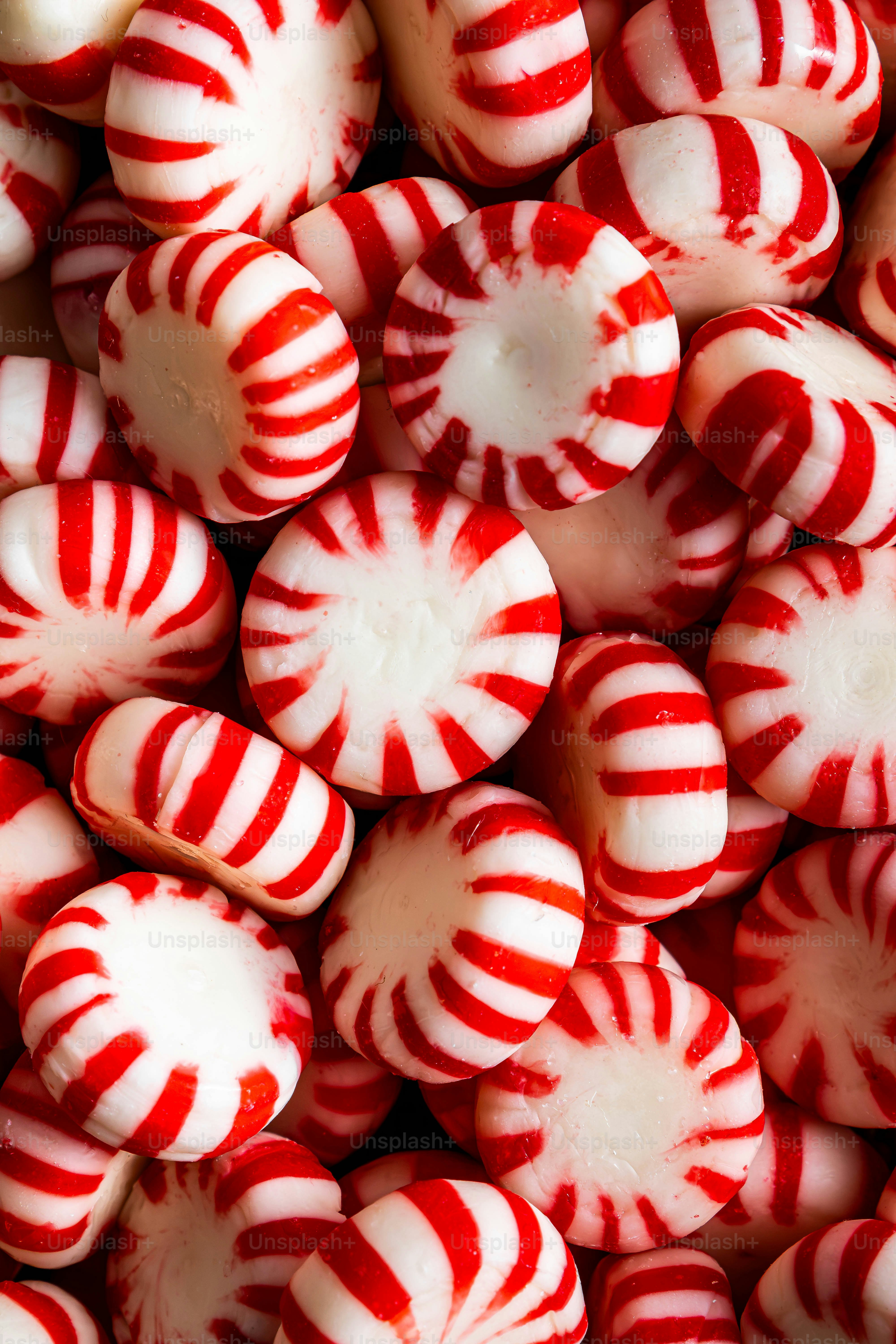 Un montón de caramelos redondos de menta blanca con rayas rojas