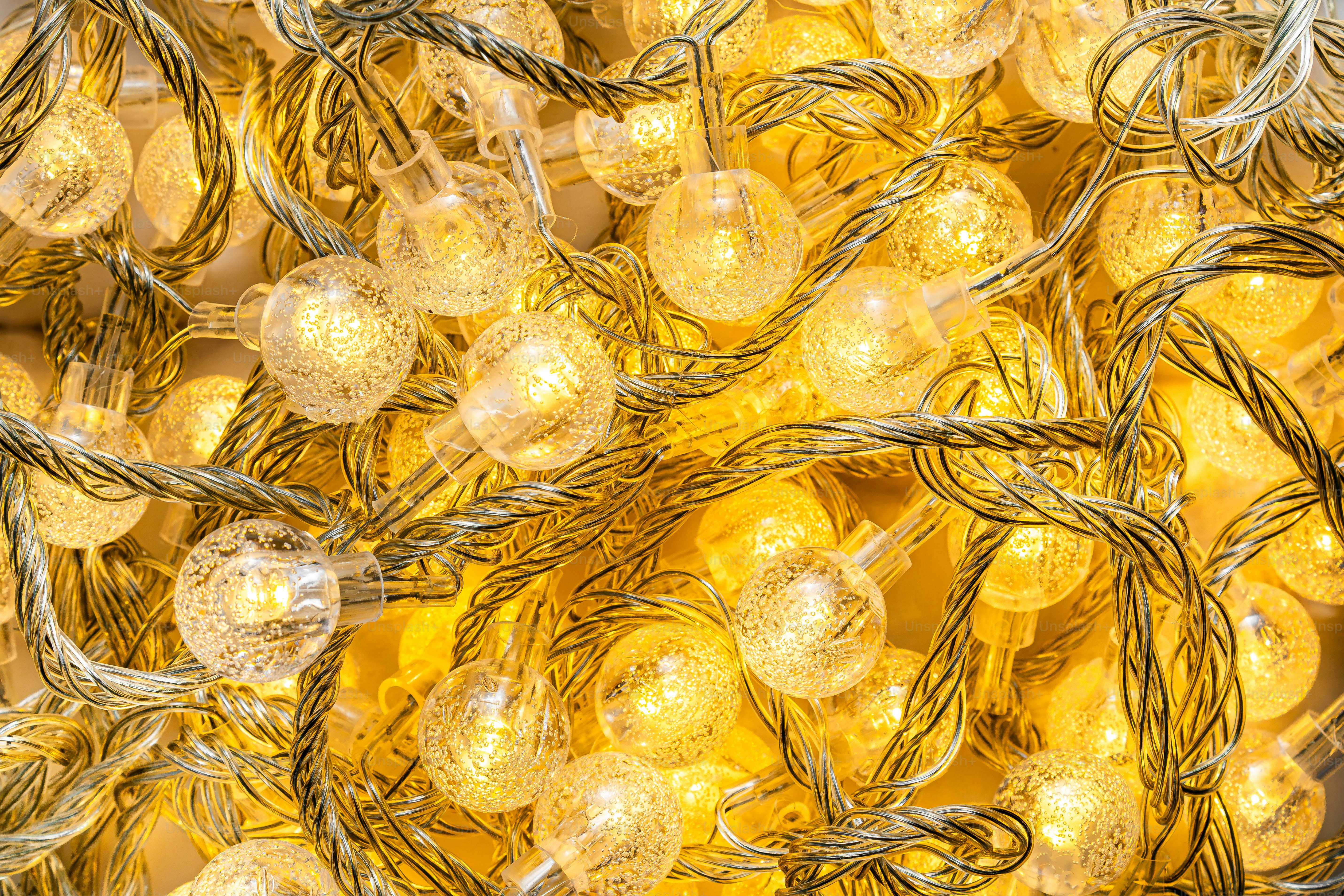 Un enredo de luces de hadas amarillas cálidas y brillantes con pequeñas esferas de cristal texturizadas