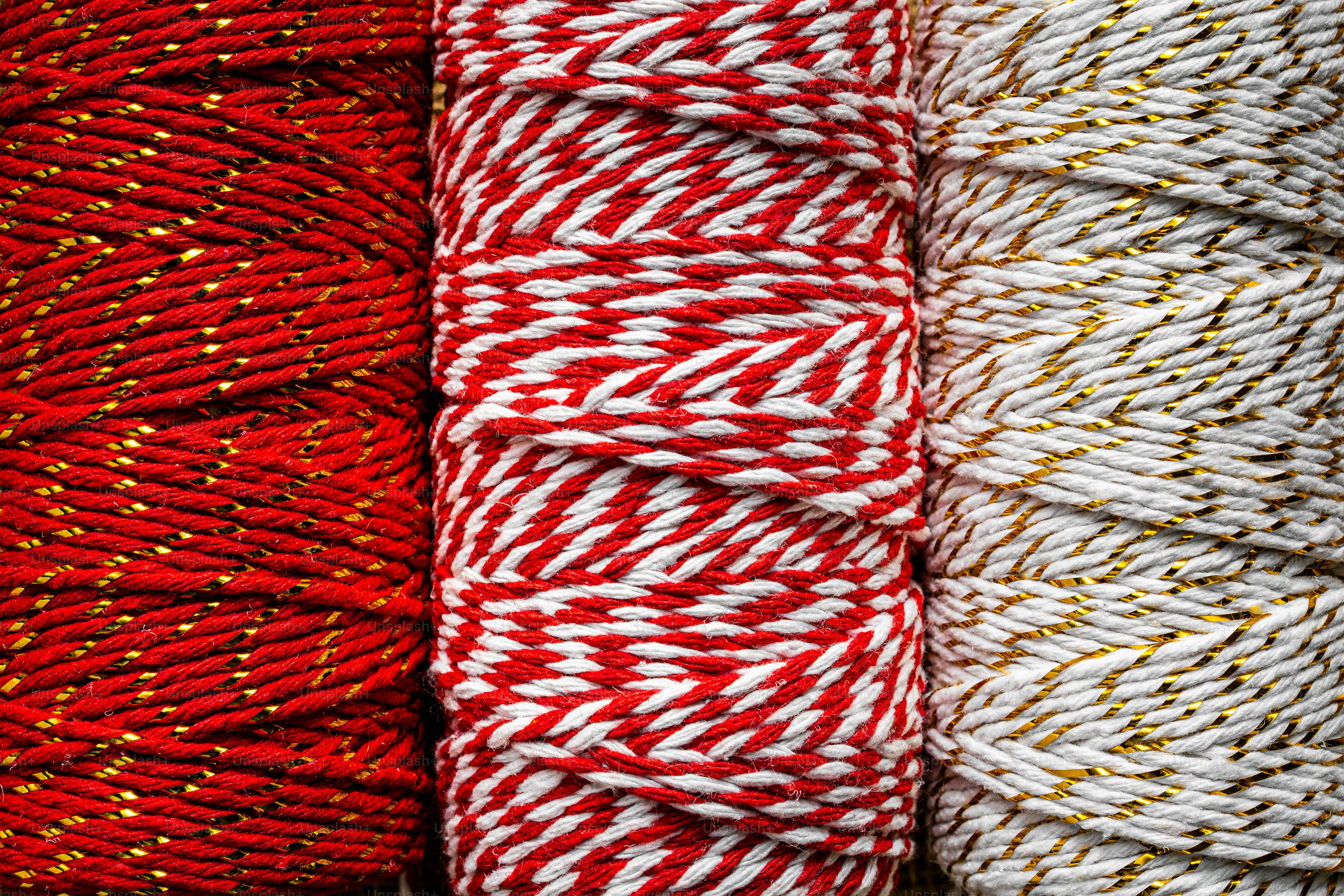 Tres carretes de rojo, rojo y blanco, y cuerda blanca con hilo dorado metálico