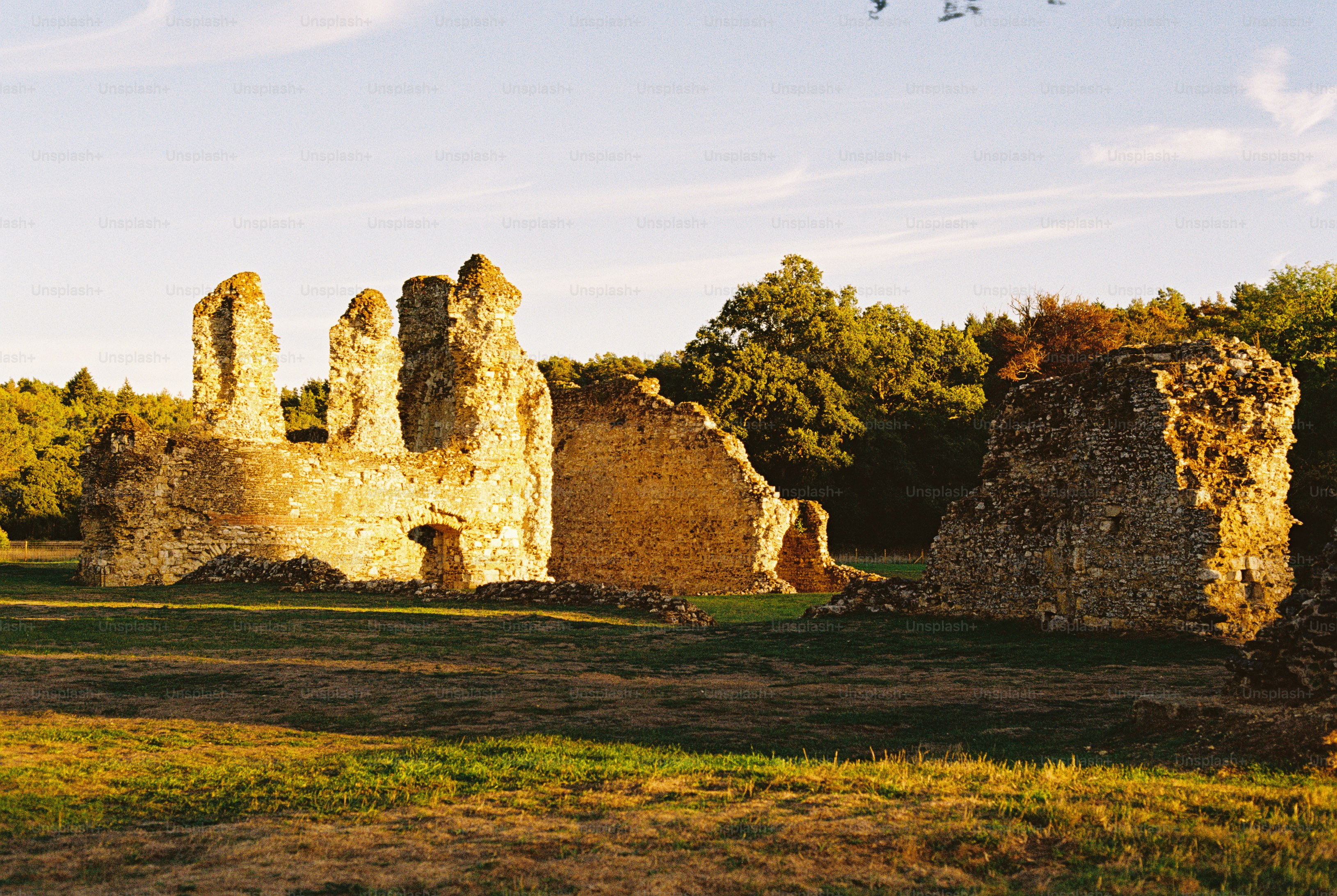 Stone ruins of an ancient building in a grassy field during golden hour