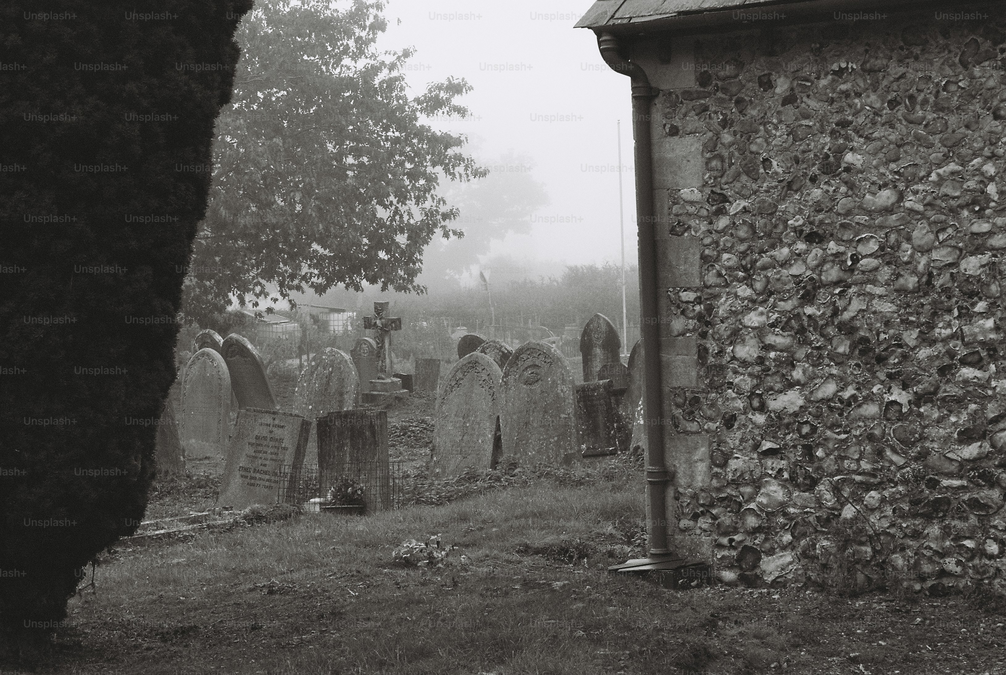 Misty graveyard with old headstones - Photo on Unsplash+