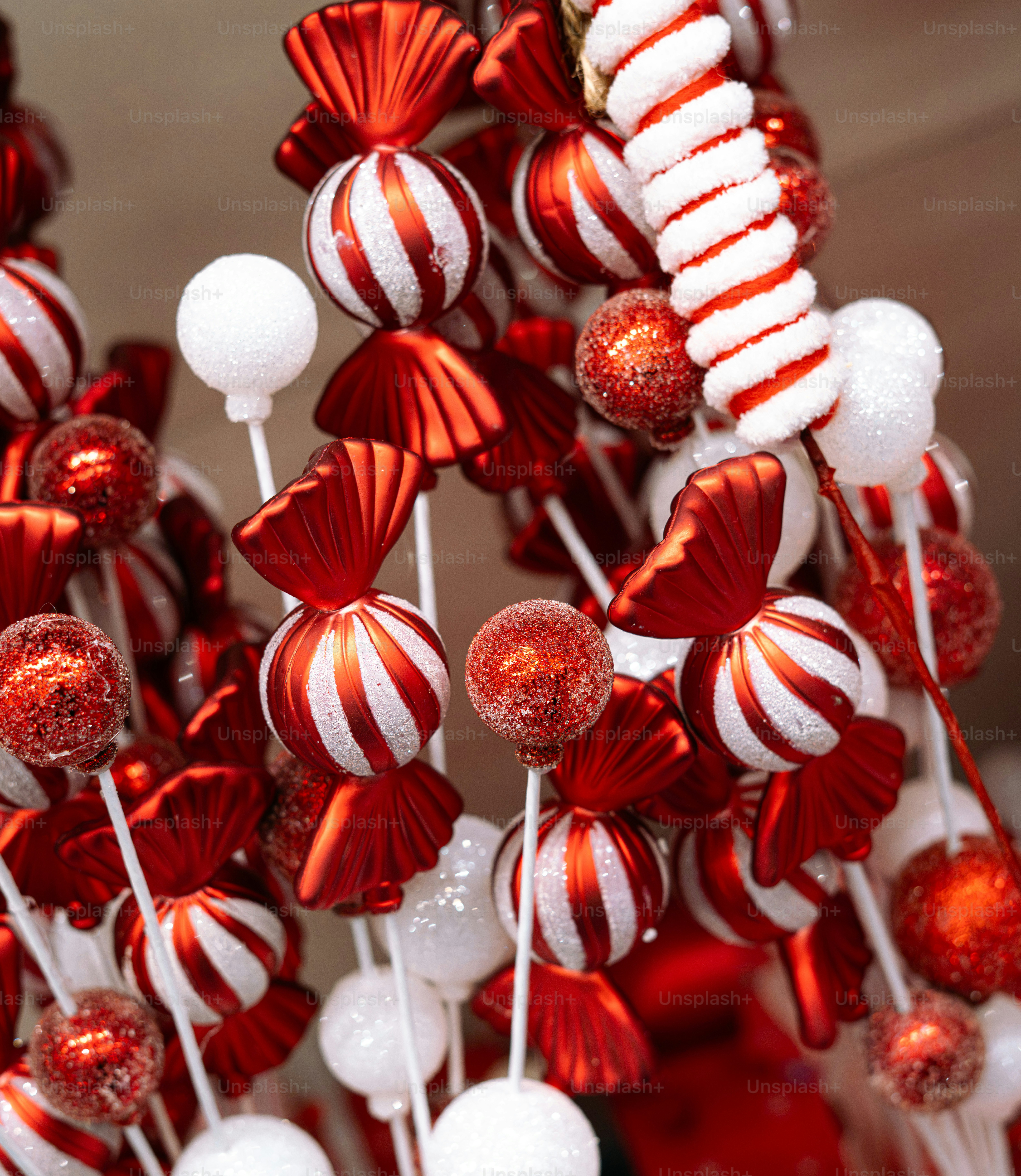 Red and white candy-shaped ornaments and glittery spheres on sticks for Christmas decoration