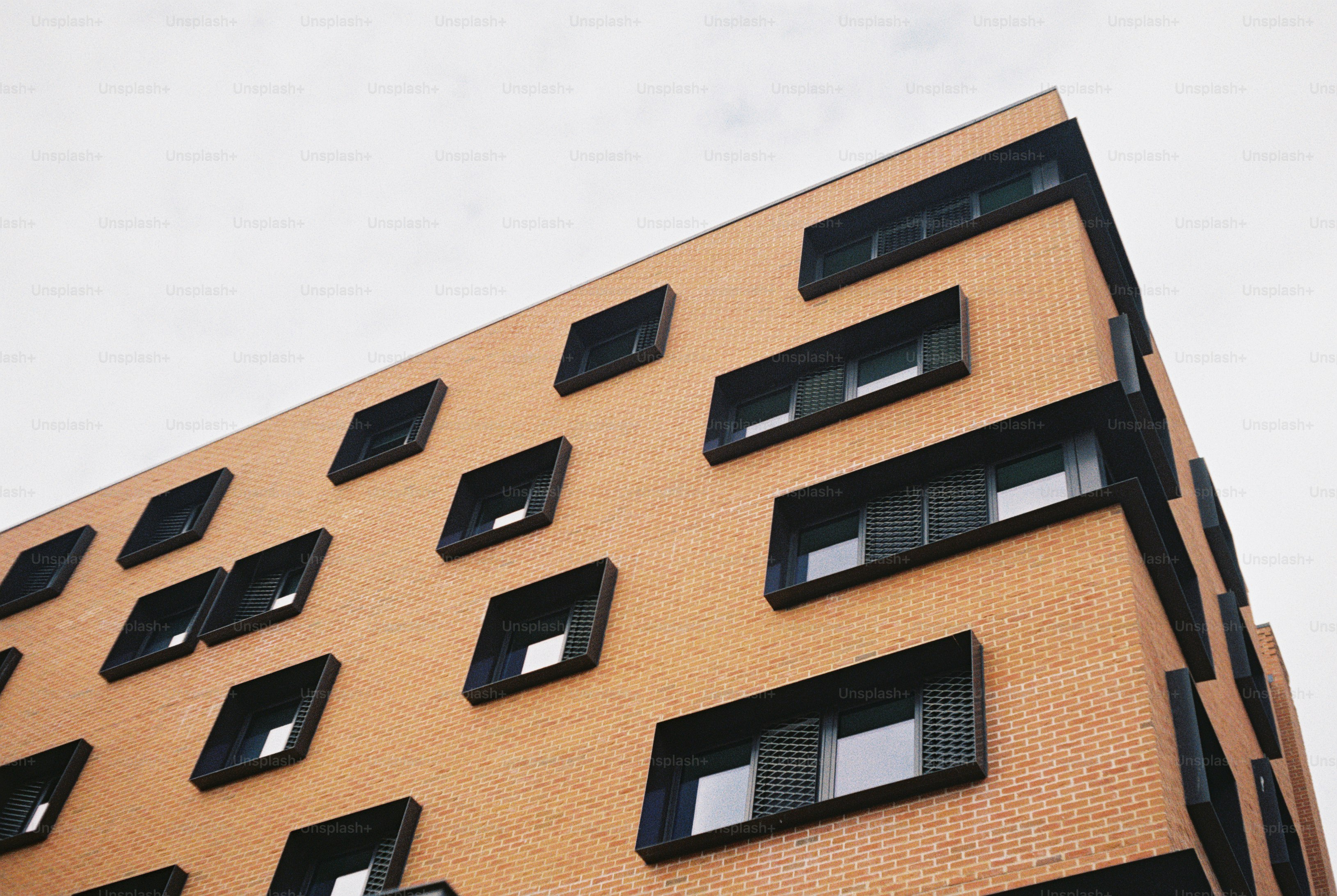 Low angle view of a modern brick building with recessed black window frames