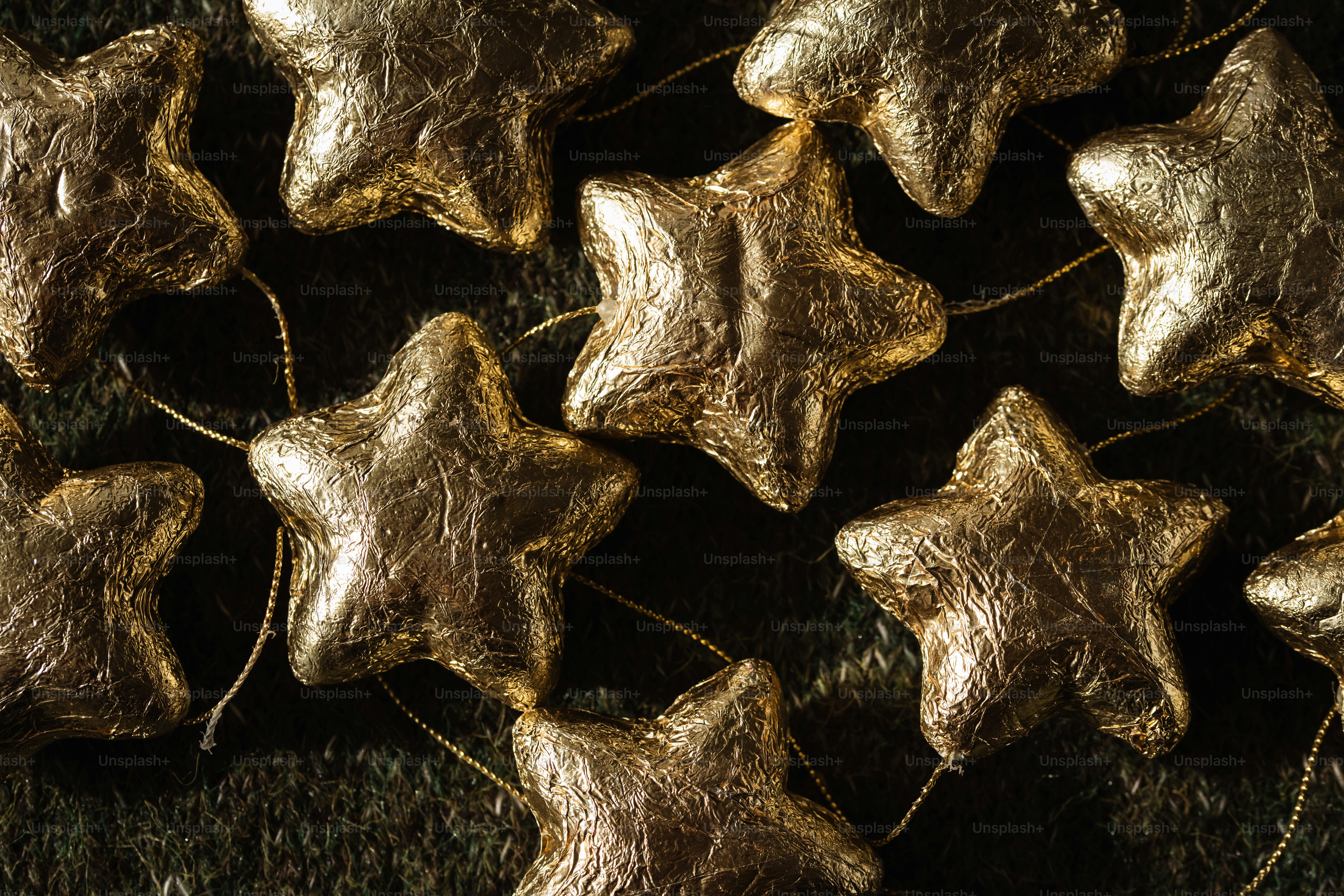 Gold foil star ornaments on a dark green textured background