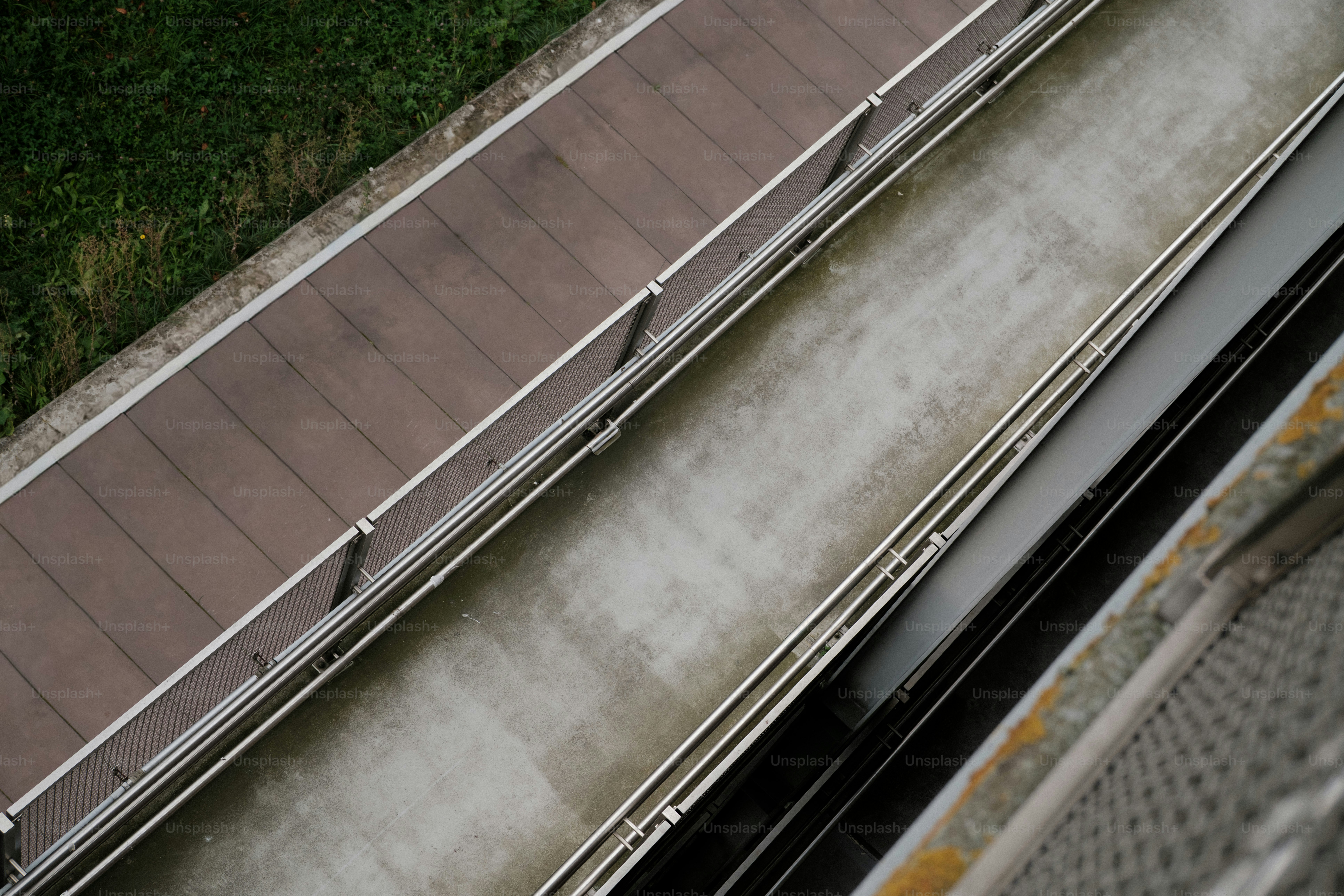 Concrete walkway beside metal fence - Photo on Unsplash+