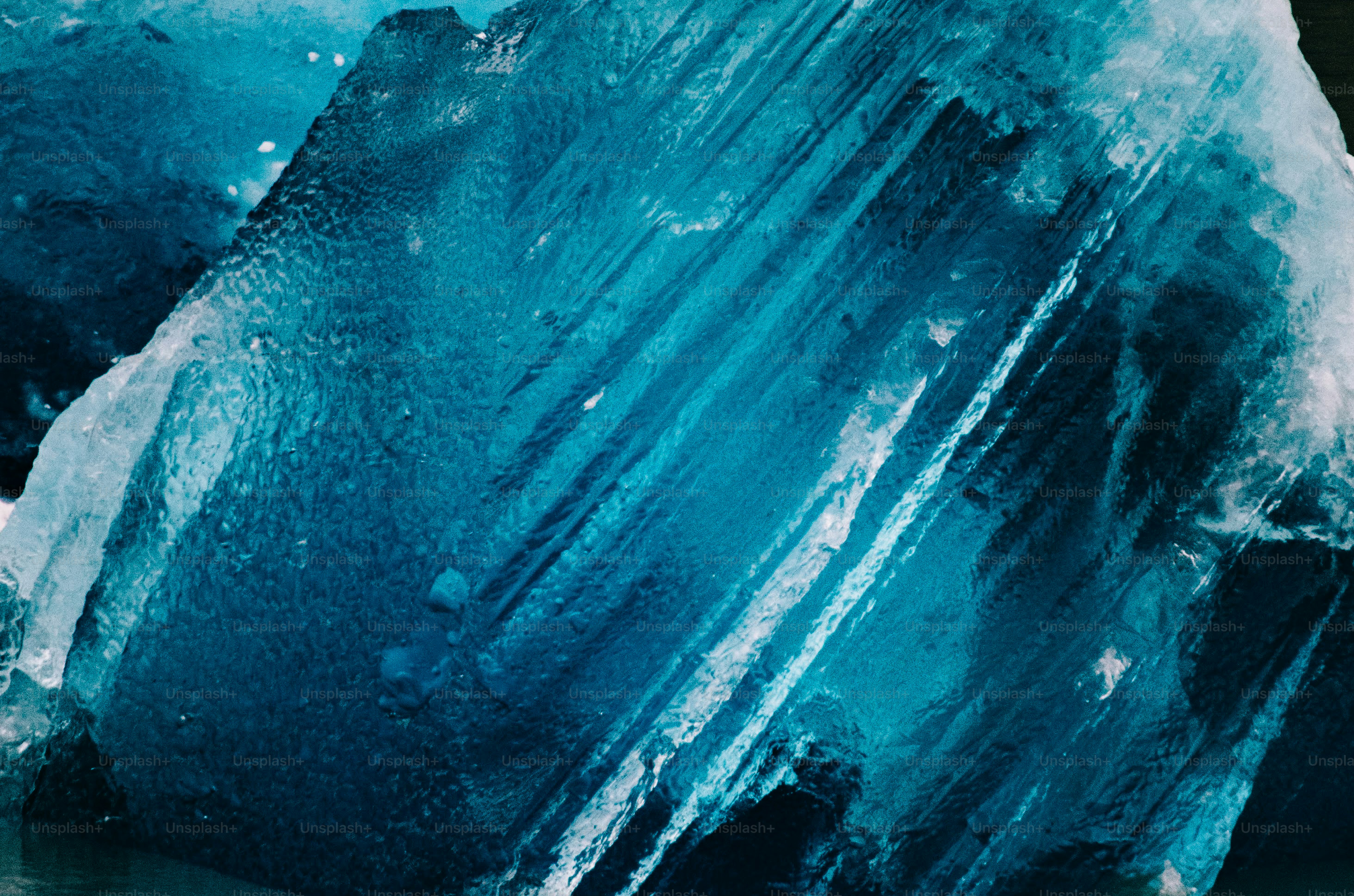 A large chunk of translucent blue glacial ice with deep ridges and textures