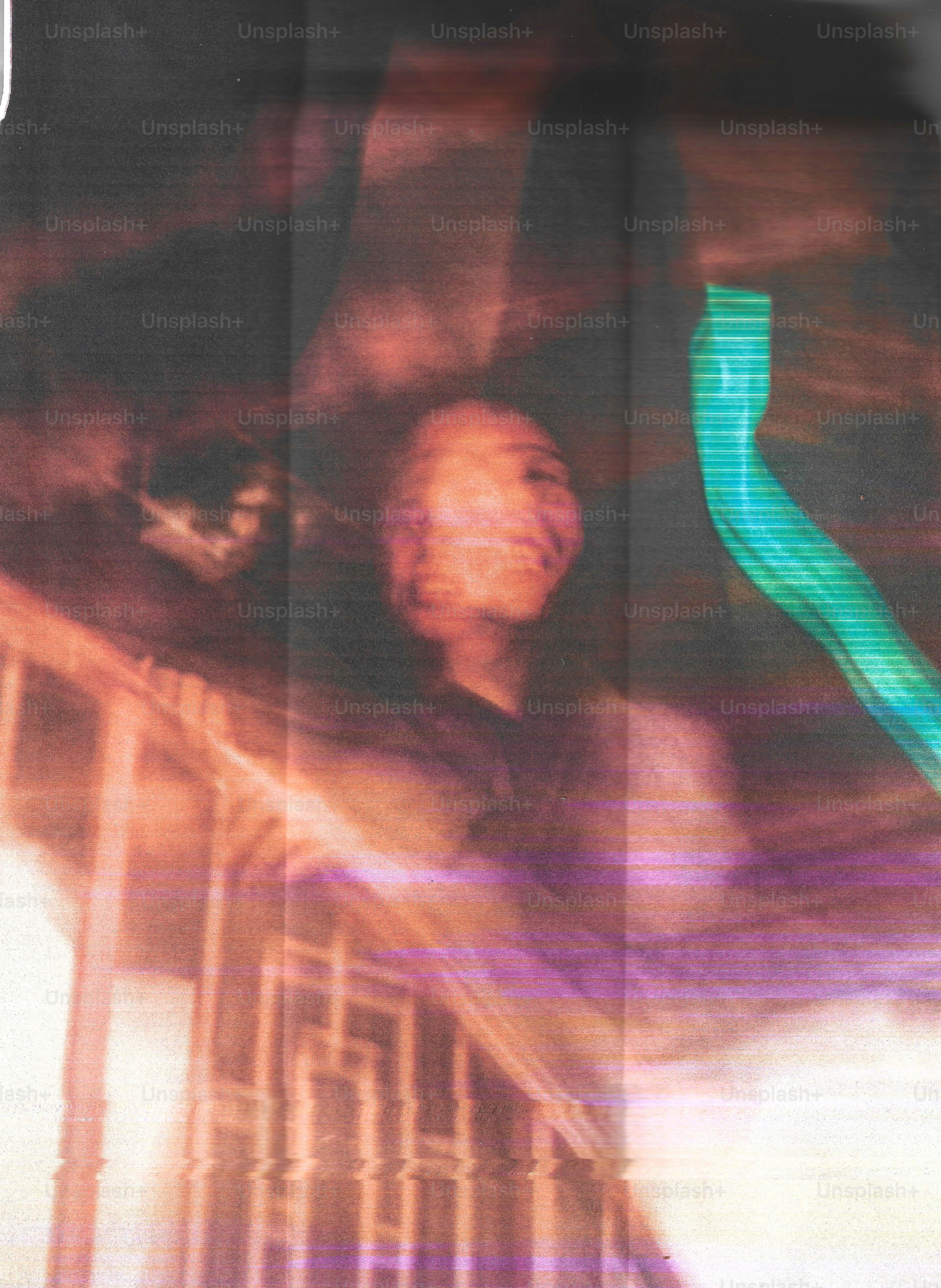 A person with a blurred face near a staircase with a bright green light streak