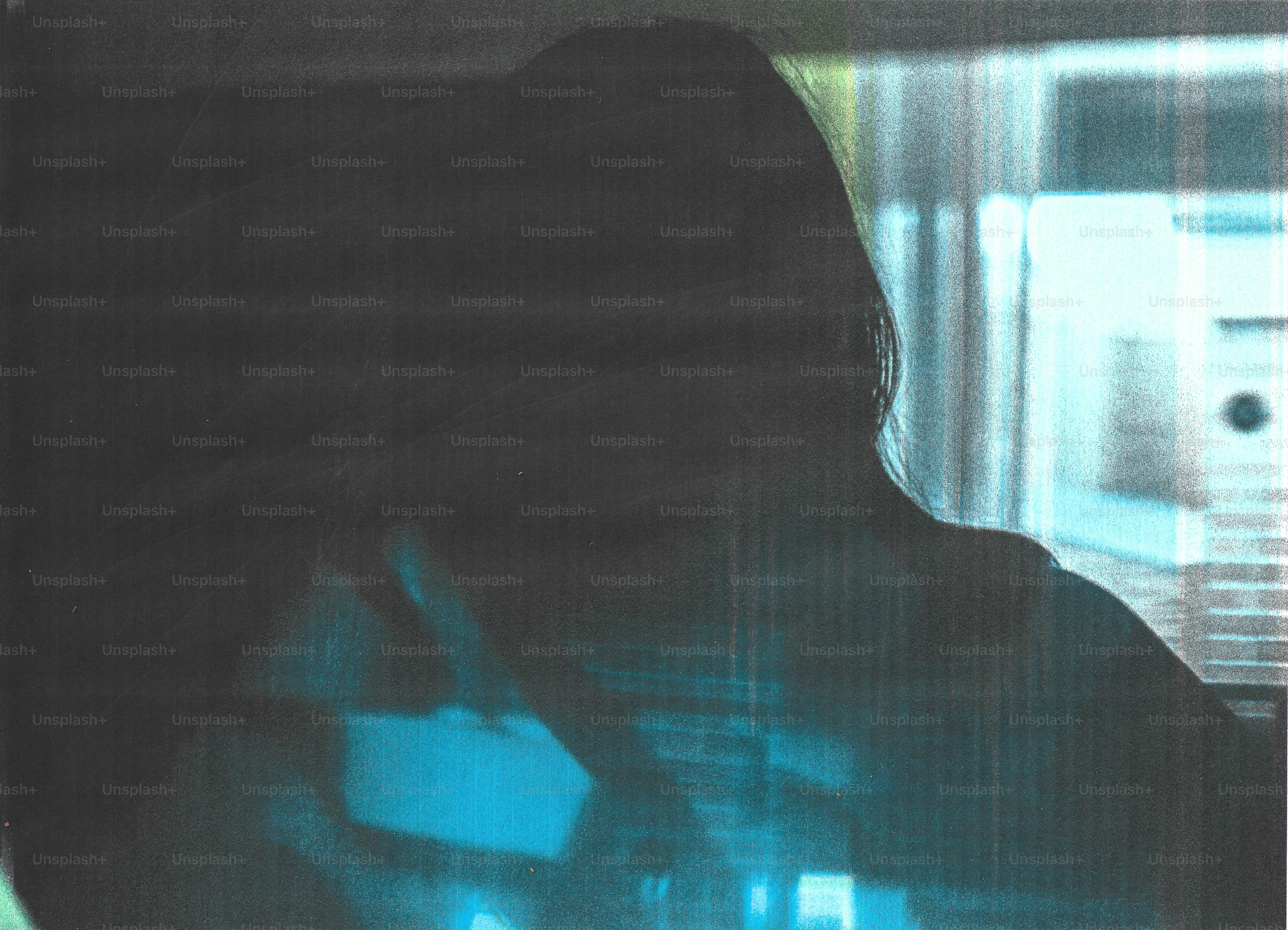 A silhouette of a person against a bright blue light with vertical film grain