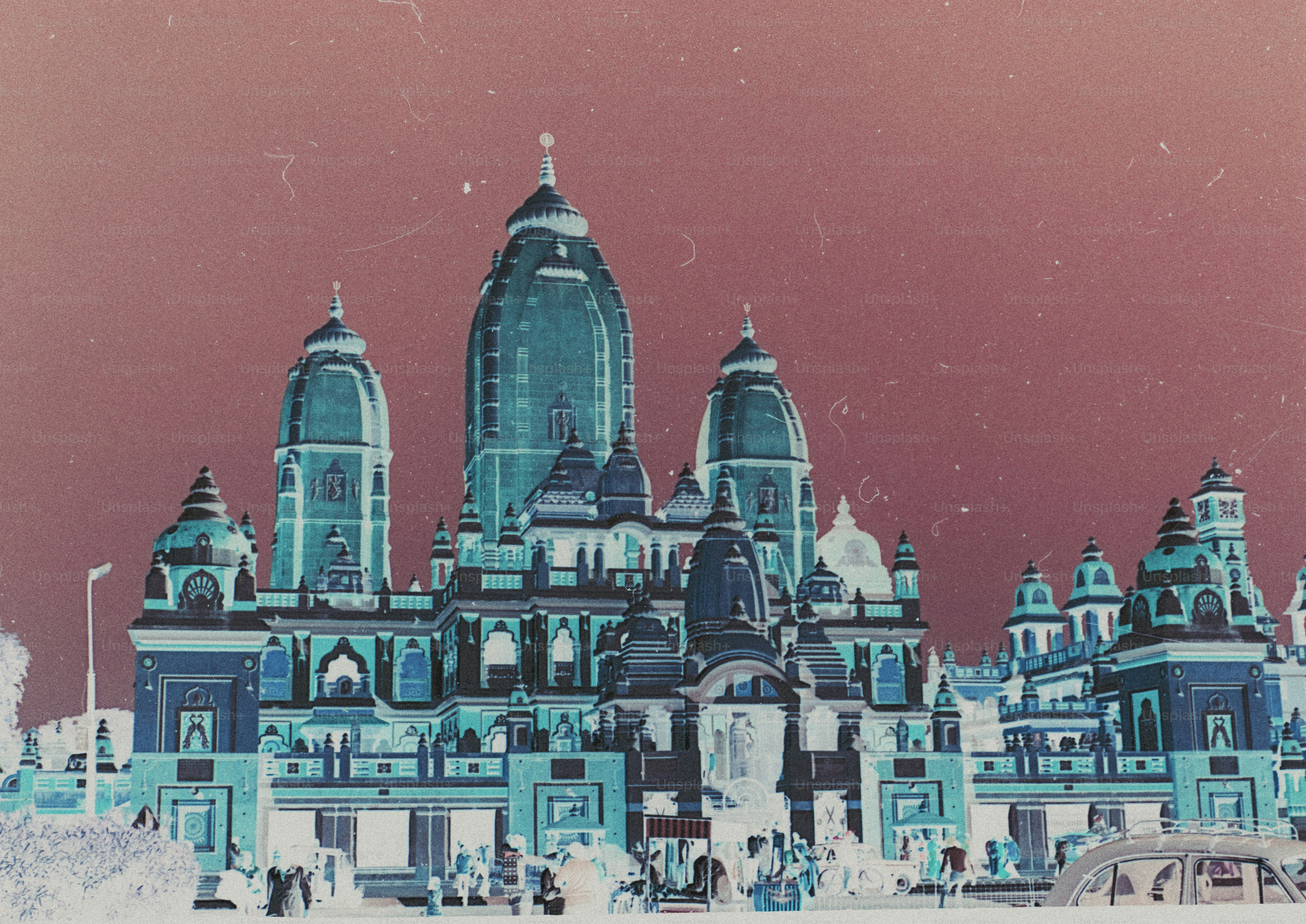 An inverted color photograph of a large Hindu temple with multiple towers against a dark sky